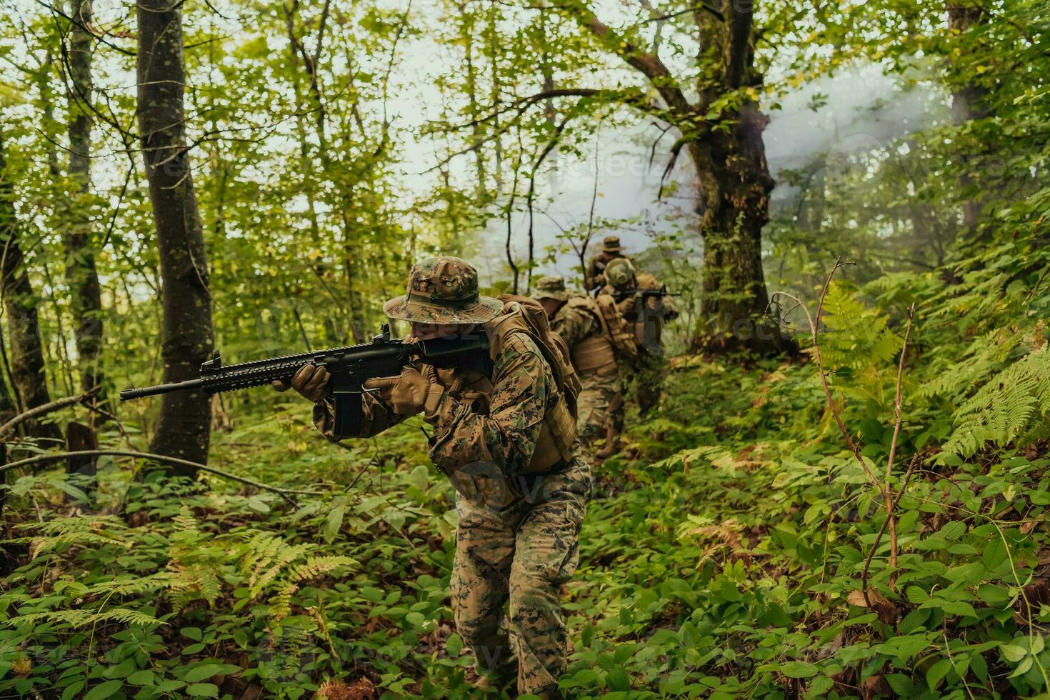 A group of modern warfare soldiers is fighting a war in dangerous remote forest areas. A group of soldiers is fighting on the enemy line with modern weapons. The concept of warfare and military conflicts photo