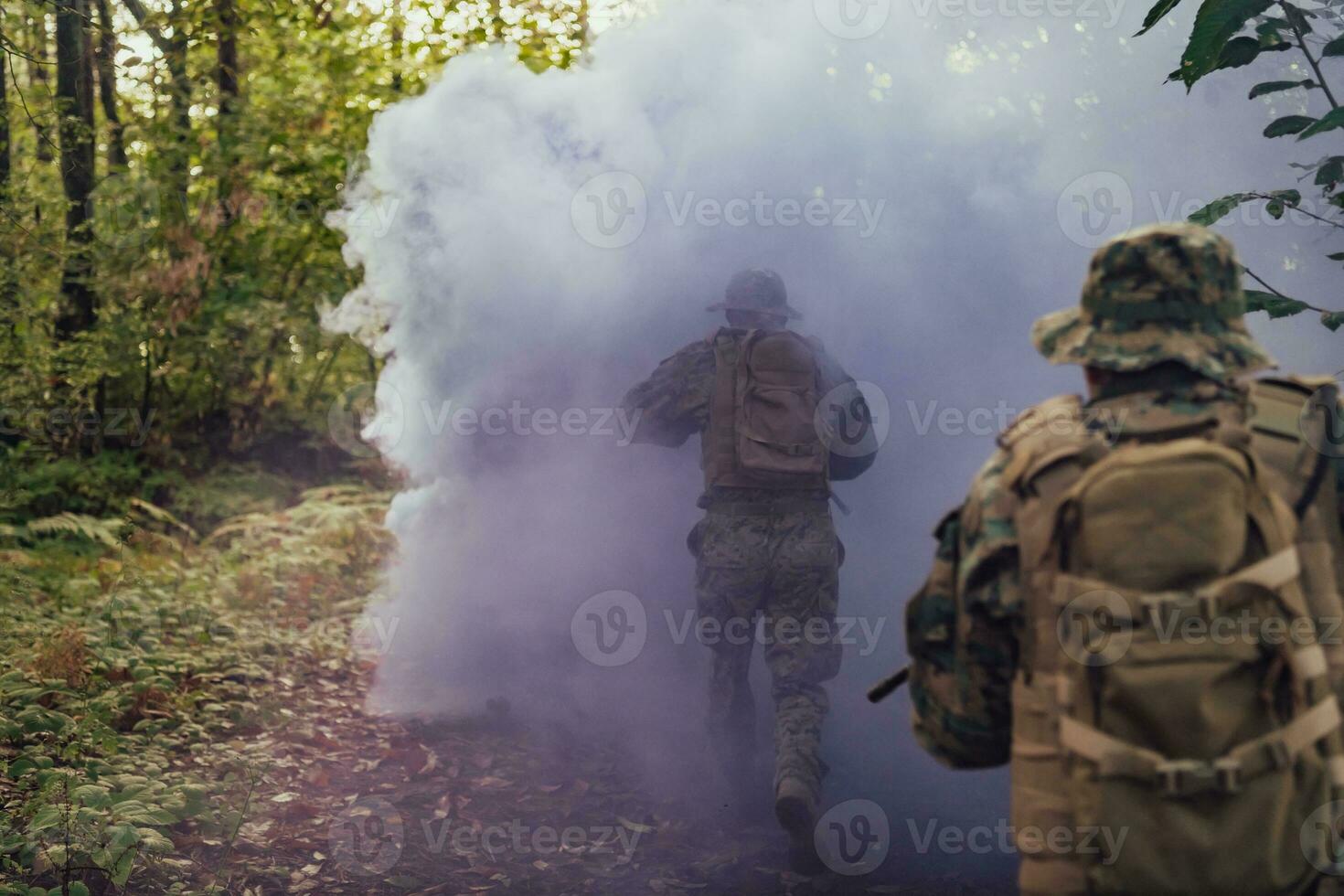 A group of modern warfare soldiers is fighting a war in dangerous remote forest areas. A group of soldiers is fighting on the enemy line with modern weapons. The concept of warfare and military conflicts photo