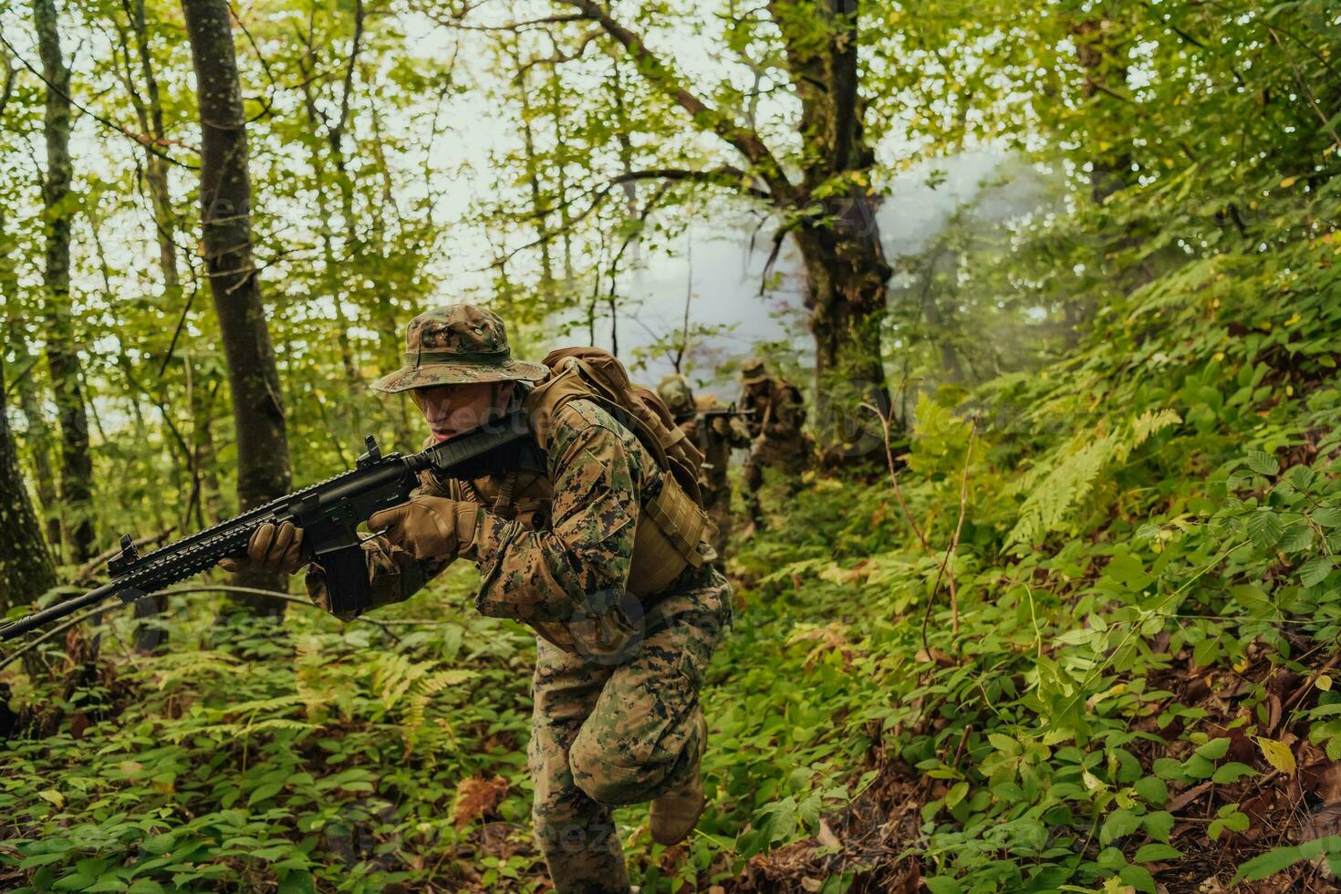 A group of modern warfare soldiers is fighting a war in dangerous remote forest areas. A group of soldiers is fighting on the enemy line with modern weapons. The concept of warfare and military conflicts photo