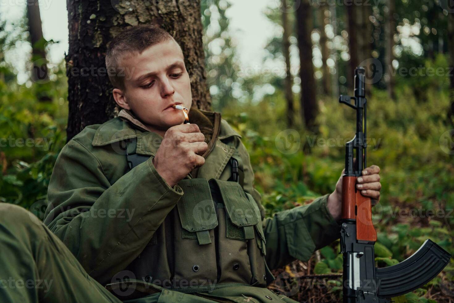 Terrorist have a break and smoke cigarette in forest during battle photo