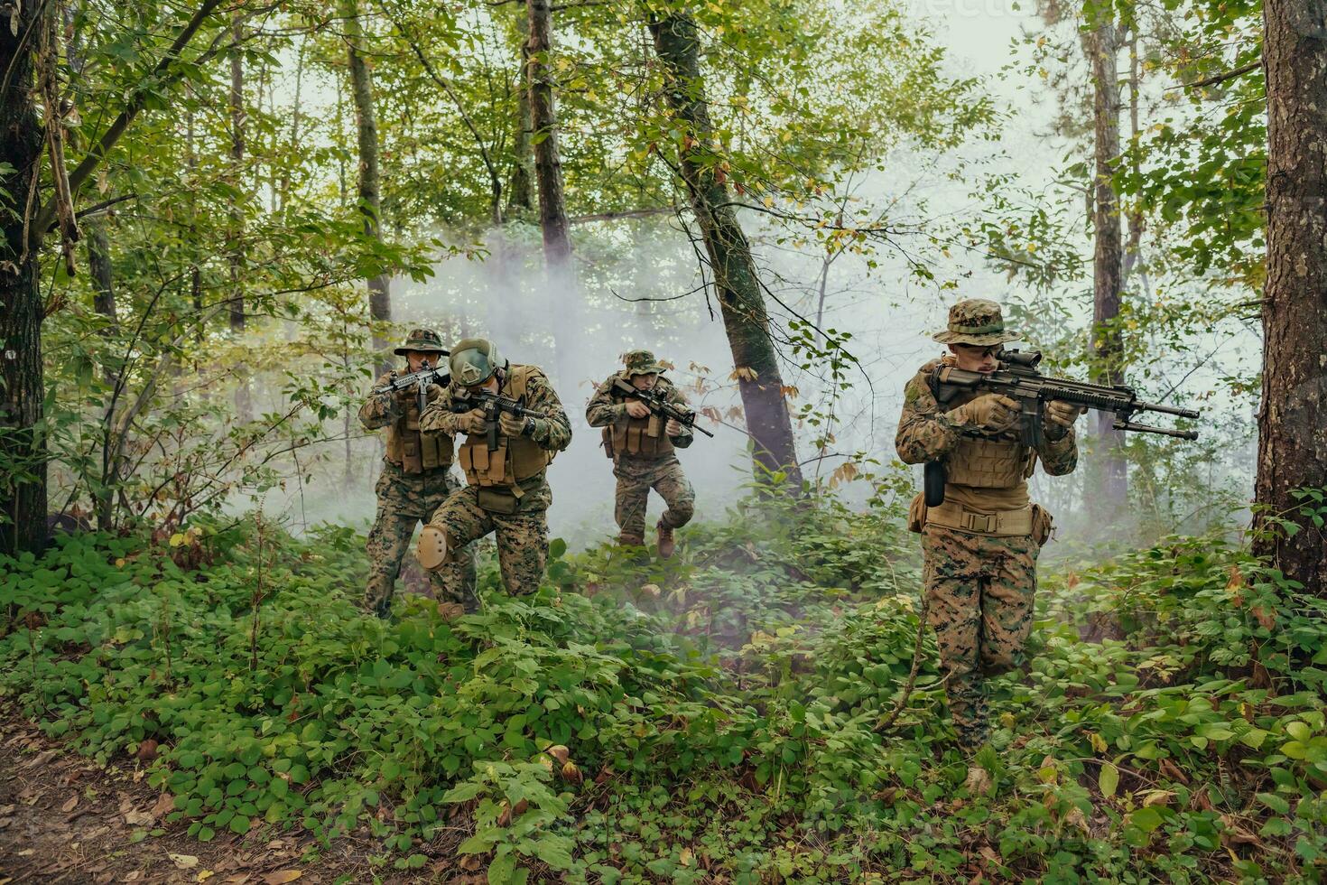 A group of modern warfare soldiers is fighting a war in dangerous remote forest areas. A group of soldiers is fighting on the enemy line with modern weapons. The concept of warfare and military conflicts photo