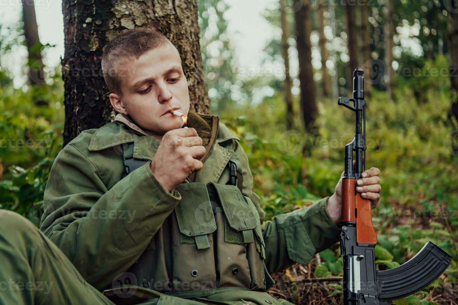 Terrorist have a break and smoke cigarette in forest during battle photo