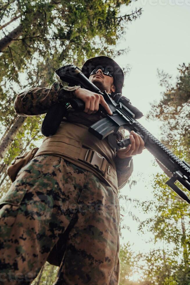 Soldier portrait with protective army tactical gear and weapon having a break and relaxing photo