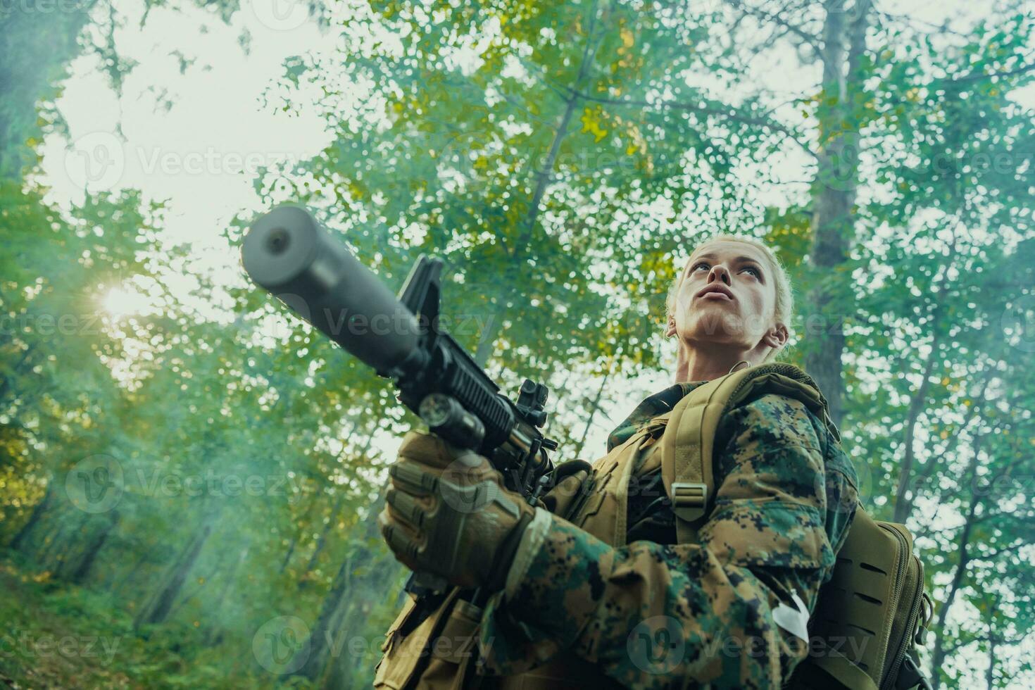 Woman soldier ready for battle wearing protective military gear and weapon photo