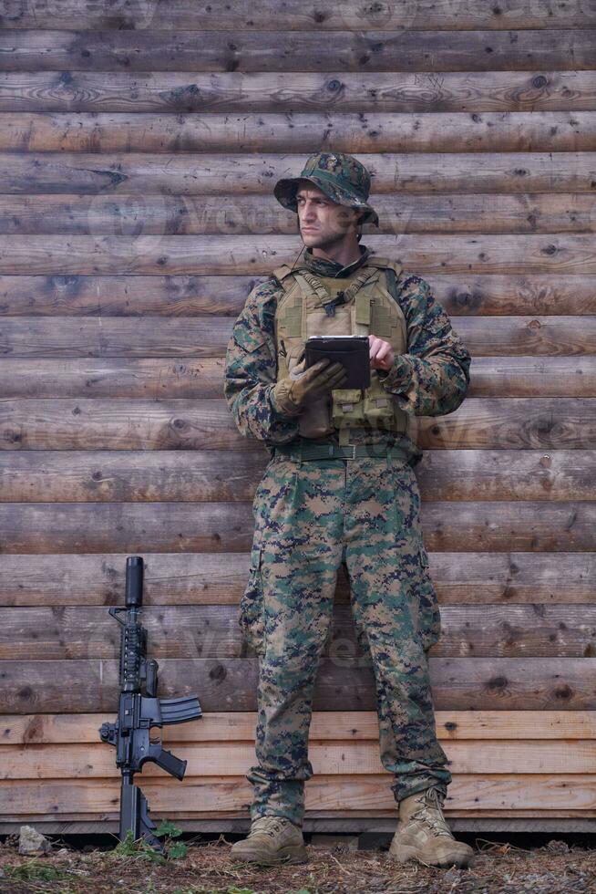 soldado que usa una tableta en un campamento militar foto