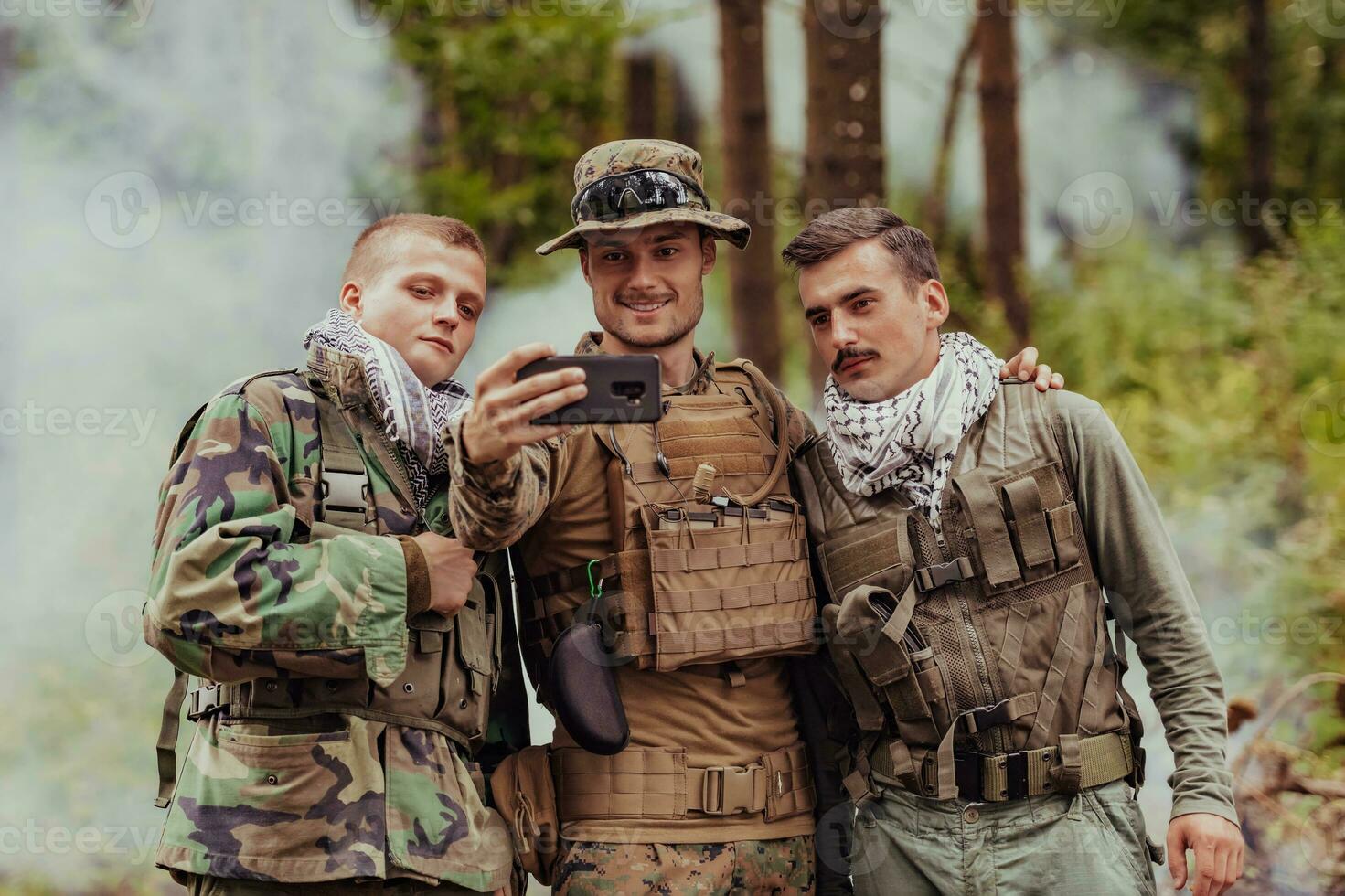 Team of soldiers and terrorist taking selfie with smartphone in the forest photo