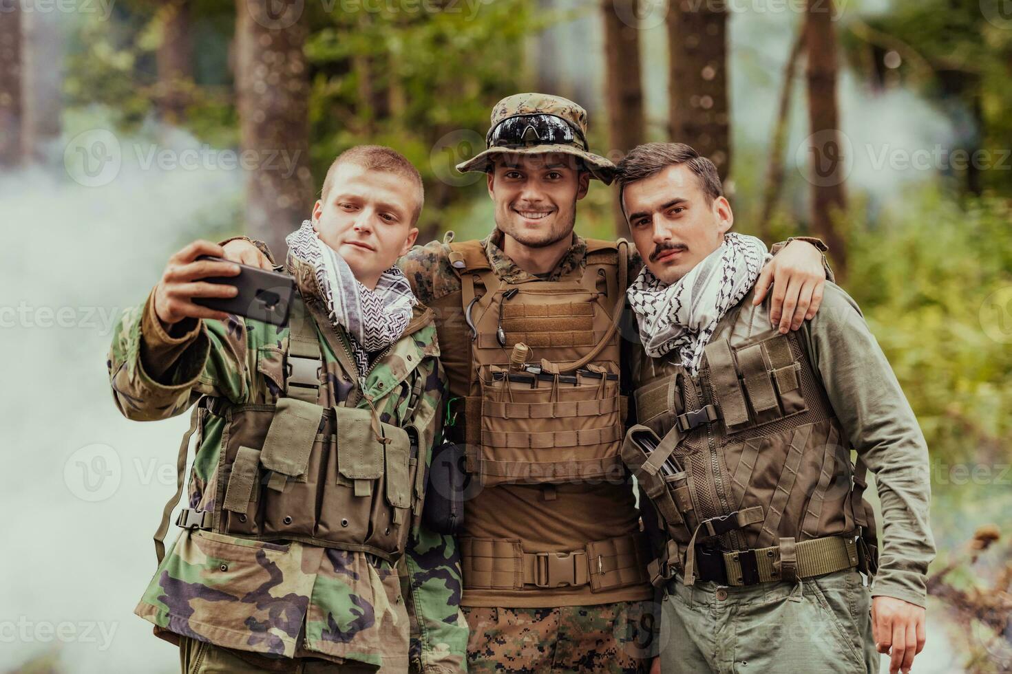 Team of soldiers and terrorist taking selfie with smartphone in the forest photo
