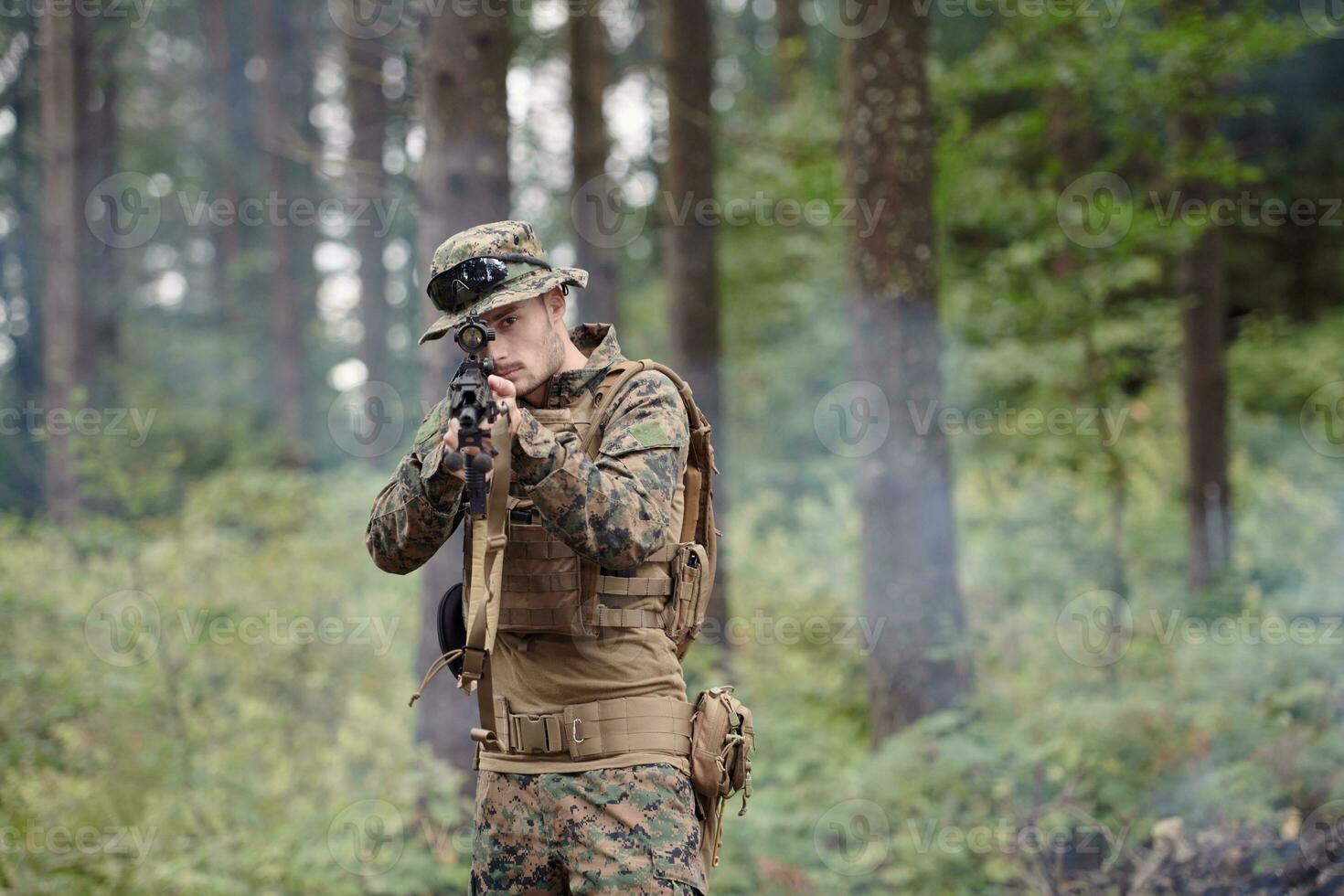 soldier in action aiming  on weapon  laser sight optics photo
