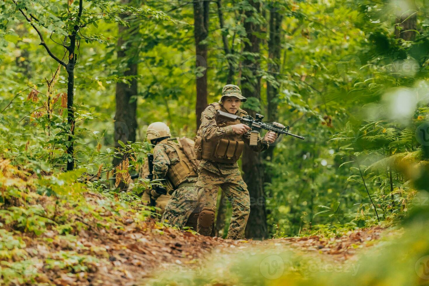 A group of modern warfare soldiers is fighting a war in dangerous remote forest areas. A group of soldiers is fighting on the enemy line with modern weapons. The concept of warfare and military conflicts photo