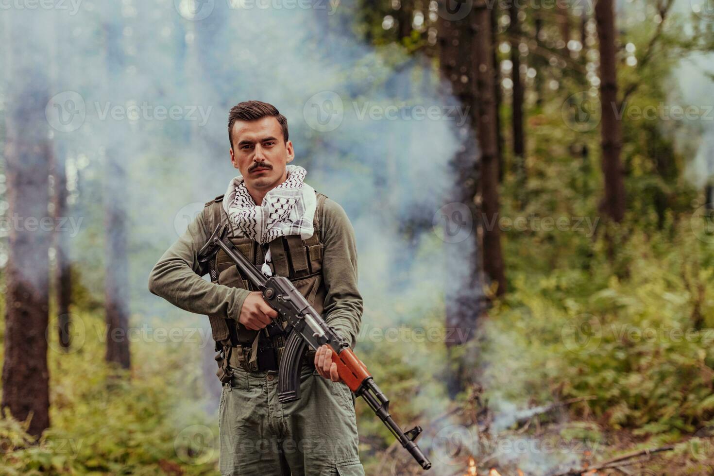 Angry terrorist militant guerrilla soldier warrior in forest photo