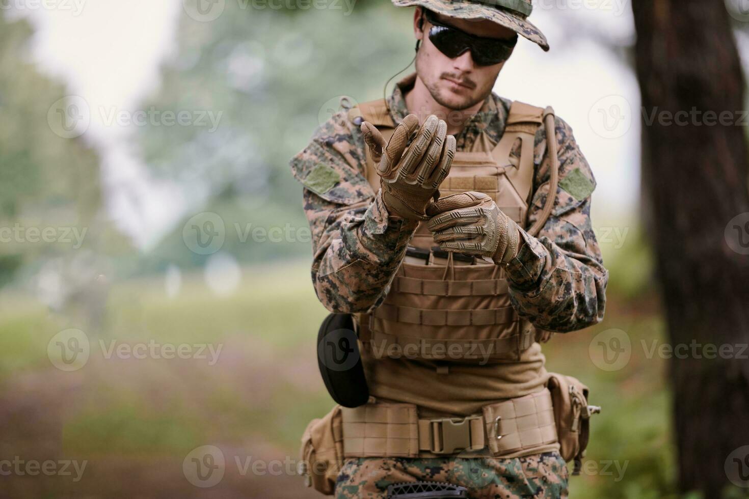 soldier preparing tactical and commpunication gear for action battle photo