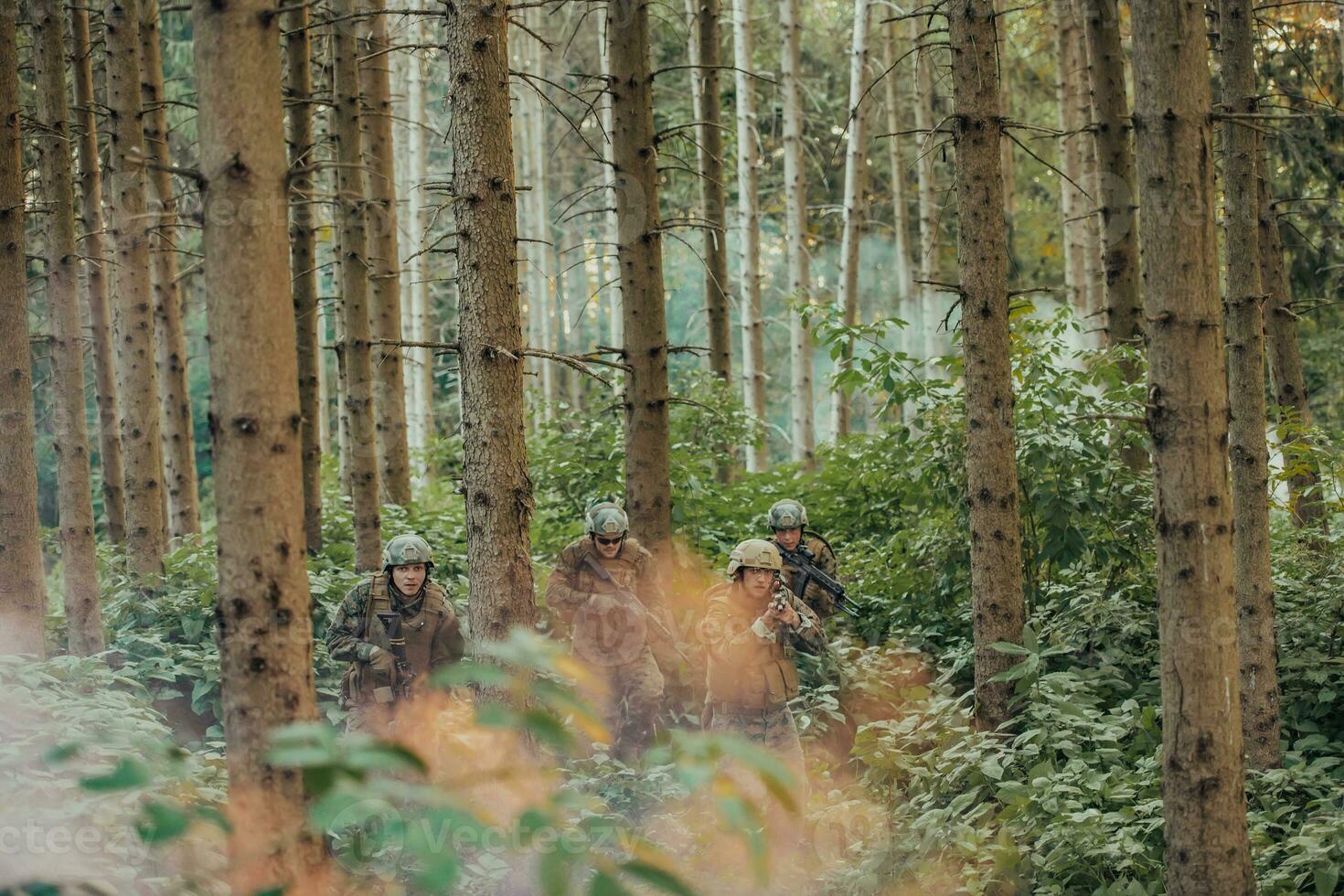 A group of modern warfare soldiers is fighting a war in dangerous remote forest areas. A group of soldiers is fighting on the enemy line with modern weapons. The concept of warfare and military conflicts photo