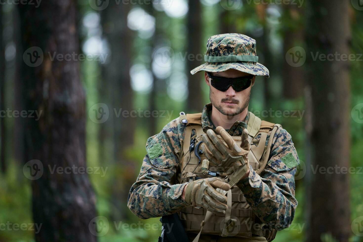 soldier preparing tactical and commpunication gear for action battle photo