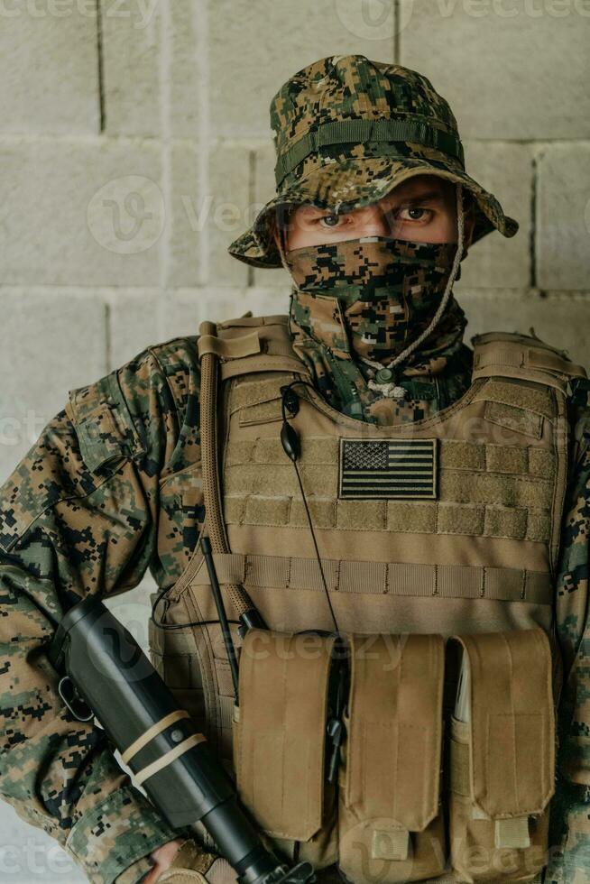 A soldier in uniform stands in front of a stone wall in full war gear preparing for battle photo