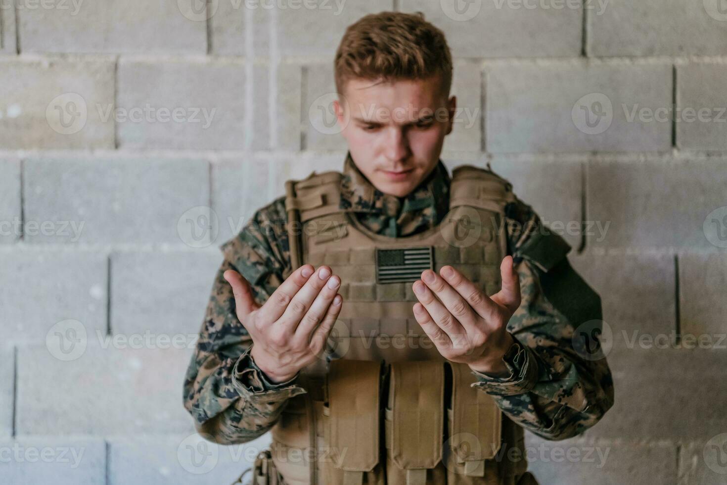 A Muslim soldier of the special forces prays to God by raising his hands and starts a prayer photo