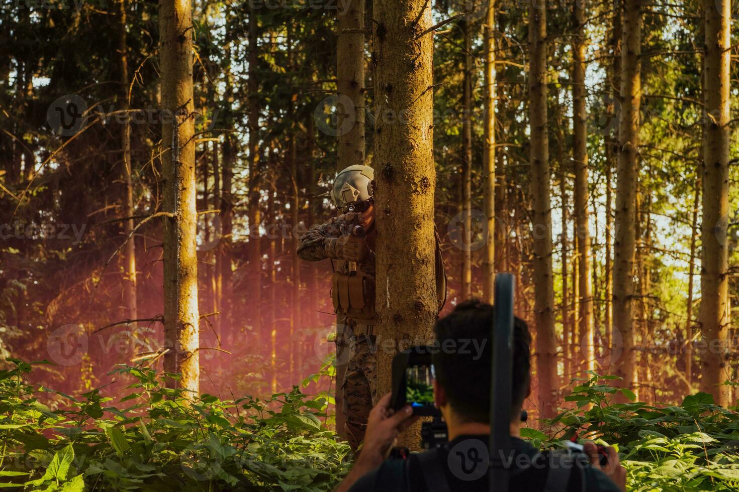 Videographer with Professional Movie Video Camera Gimbal Stabilizing Equipment Taking Action Shoot of Soldiers in Action in Forest photo