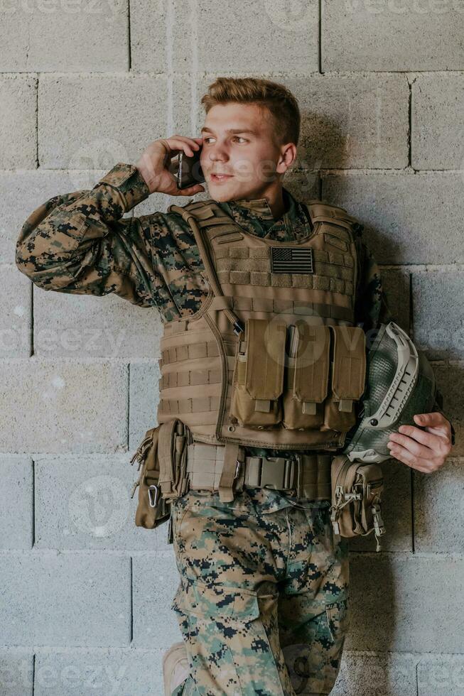 Soldier using smartphone and calling home family and friends photo