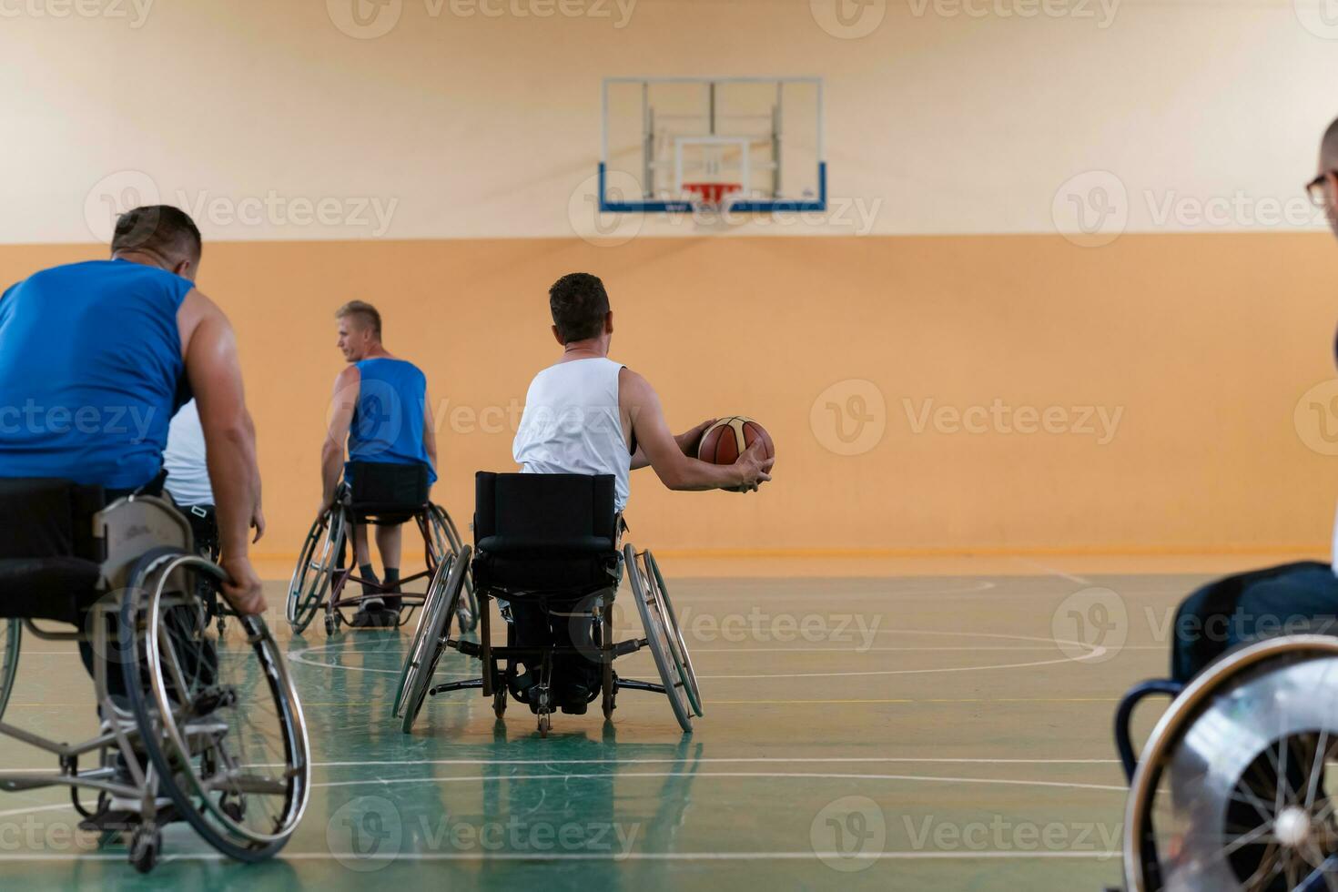 handicapped war veterans in wheelchairs with professional equipment play basketball match in the hall.the concept of sports with disabilities photo