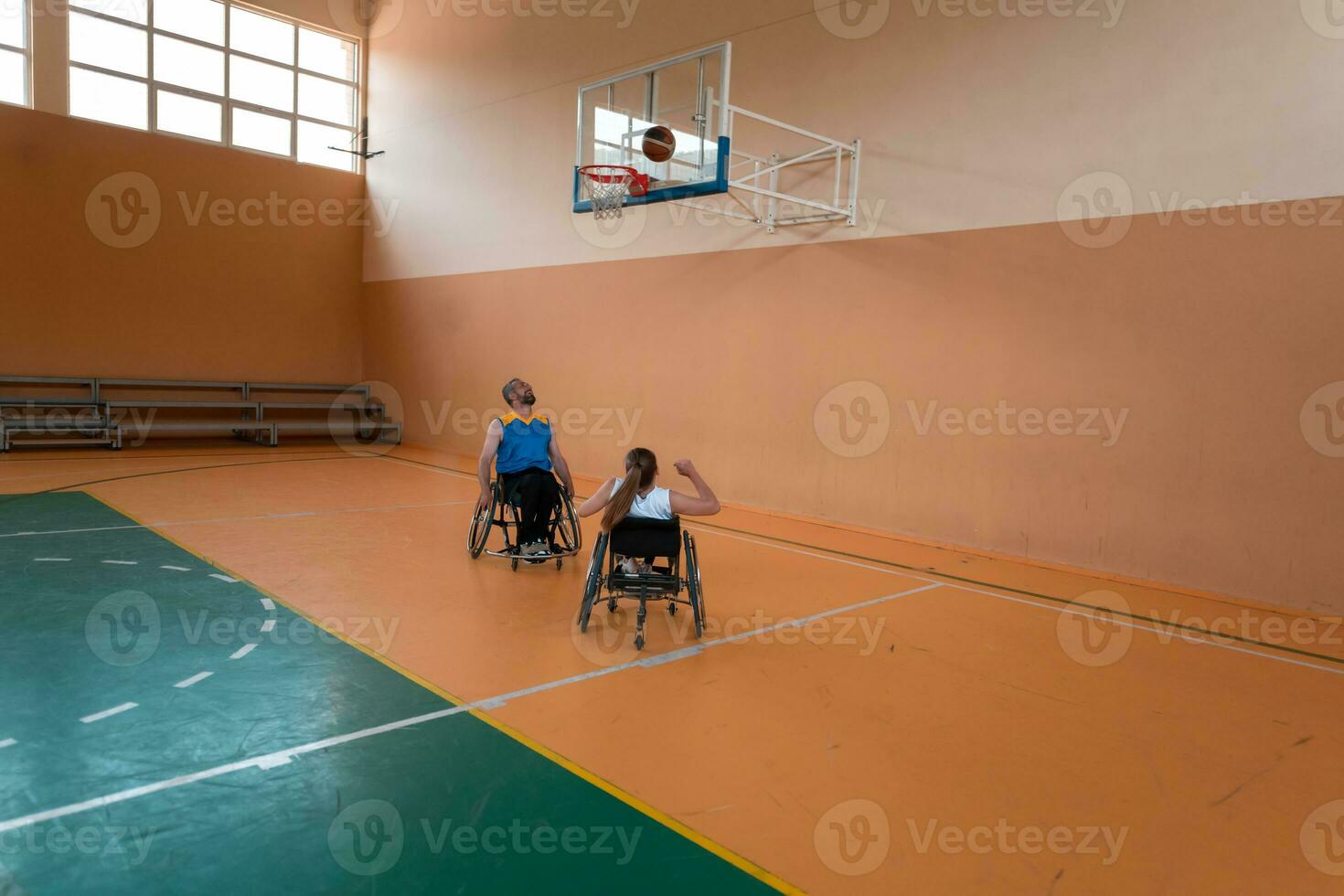 Disabled War veterans mixed race opposing basketball teams in wheelchairs photographed in action while playing an important match in a modern hall. photo