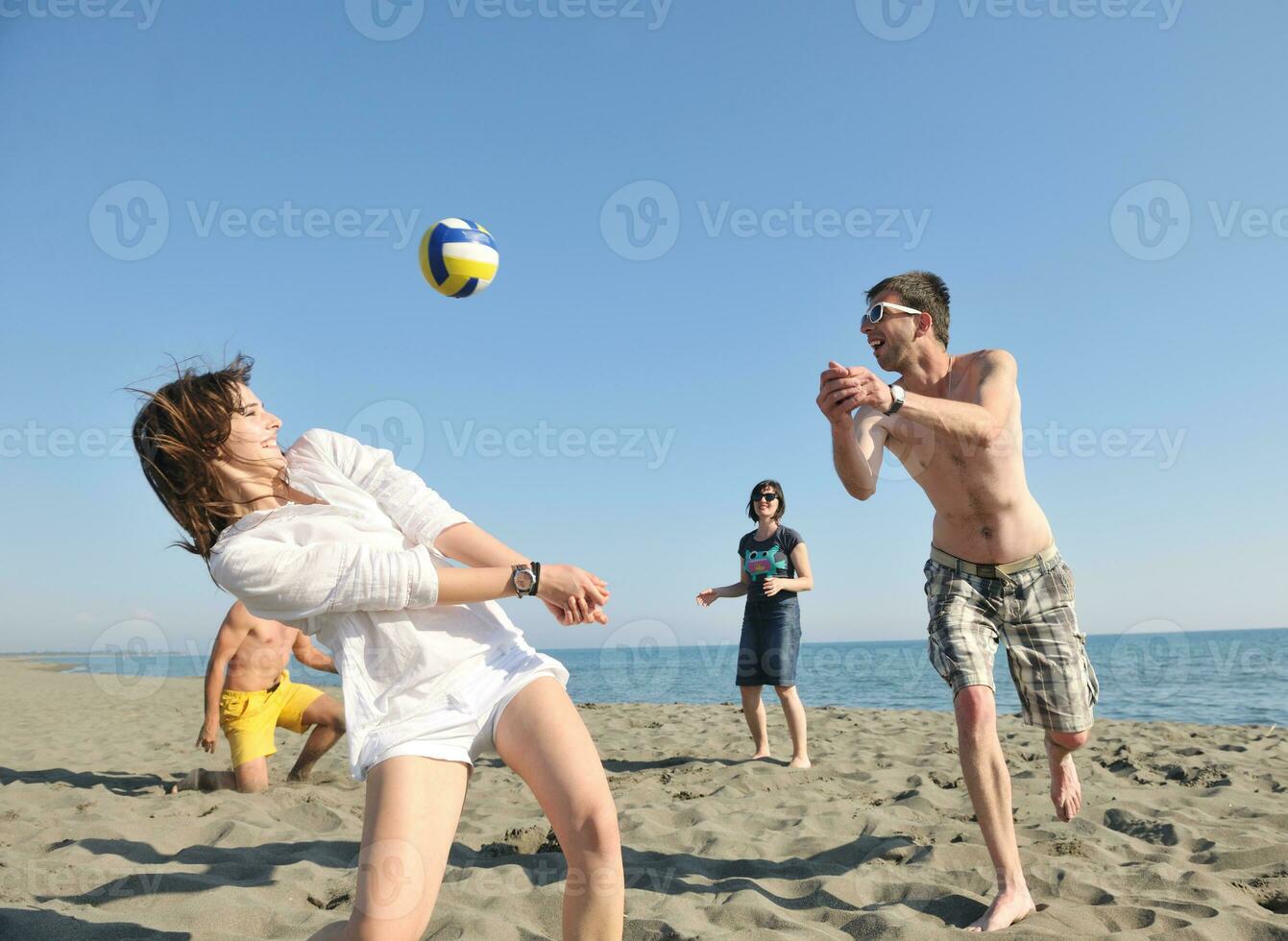 young people group have fun and play beach volleyball photo