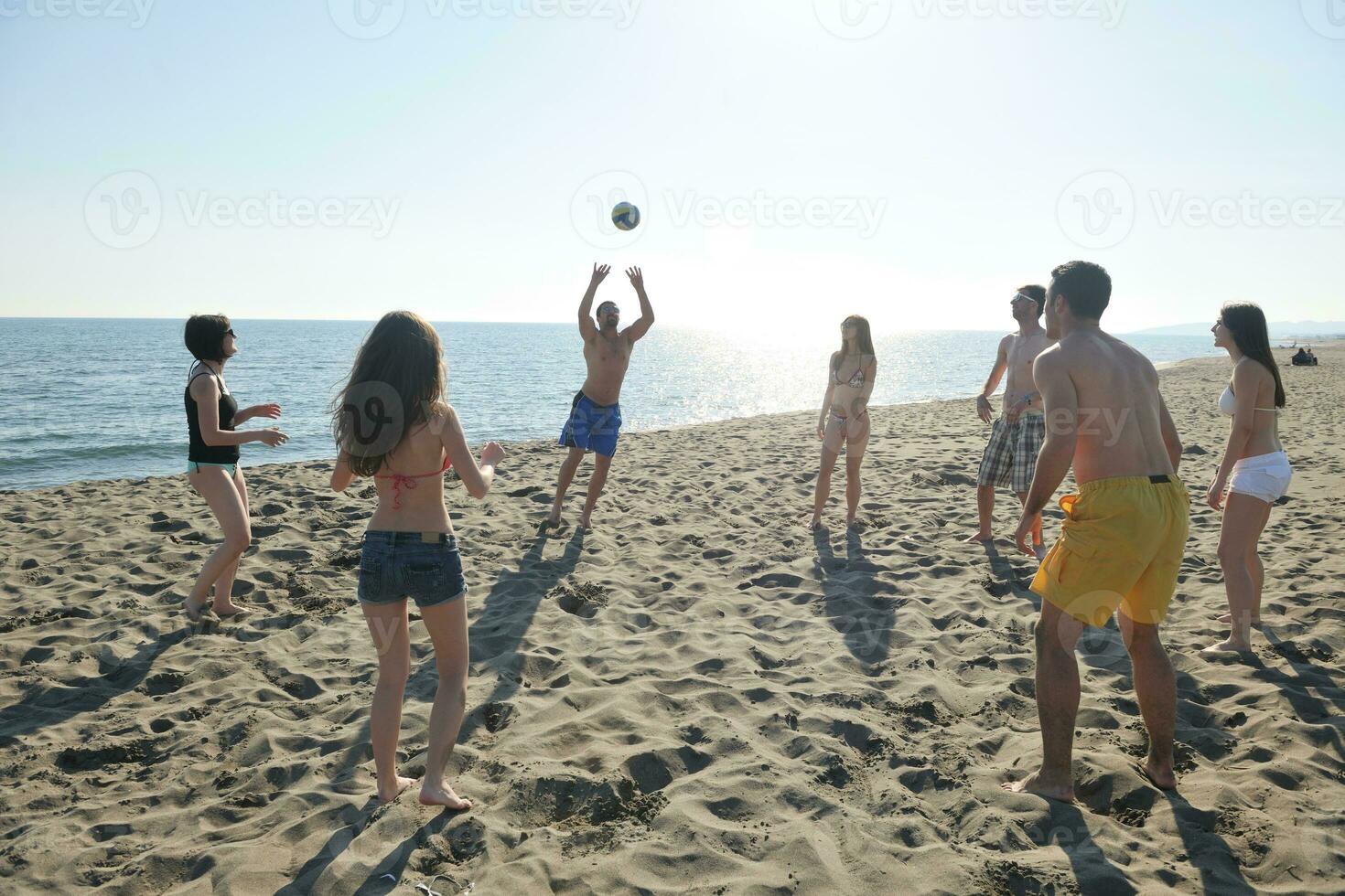 young people group have fun and play beach volleyball photo