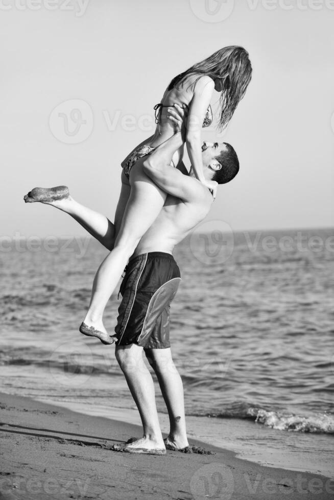 feliz pareja joven tiene tiempo romántico en la playa foto