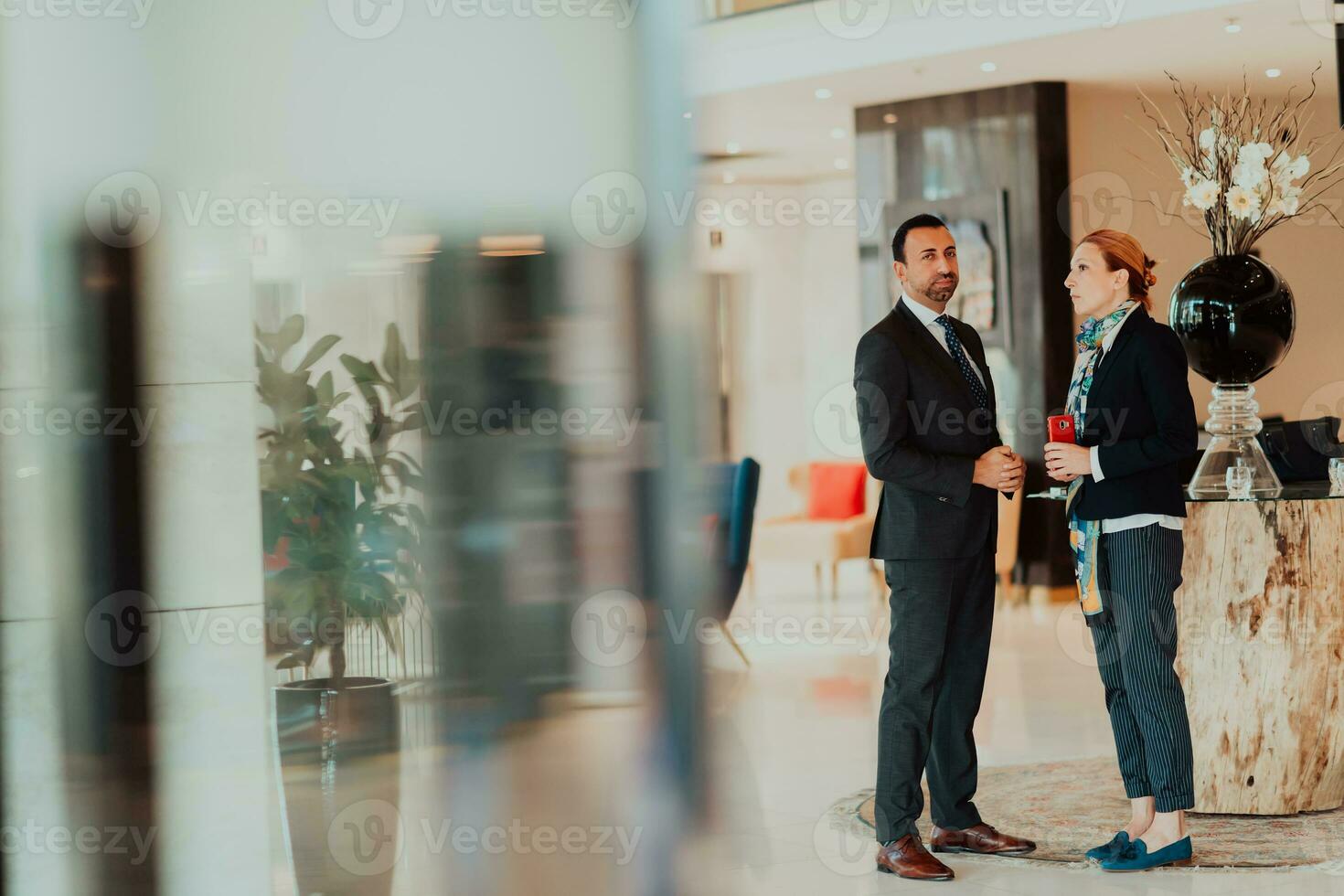 Photo of a businessman and businesswoman discussing business projects in a modern corporation. Selective focus