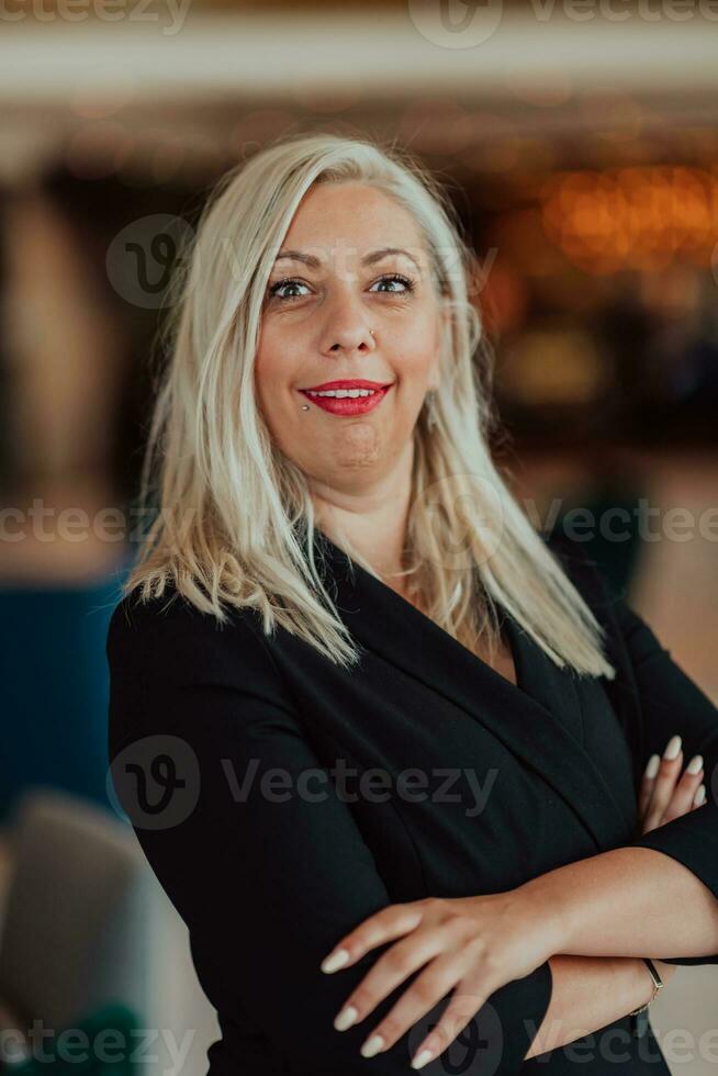 Portrait of business senior woman with crossed arms standing in modern corporation. Selective focus photo