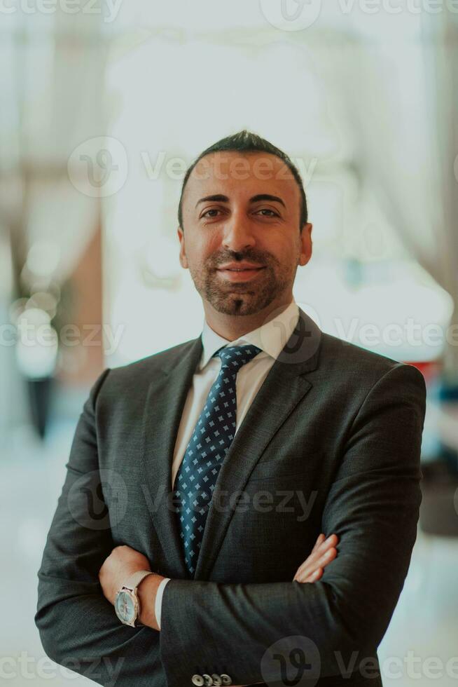 Portrait of a businessman in a suit with his arms crossed in a modern office building photo