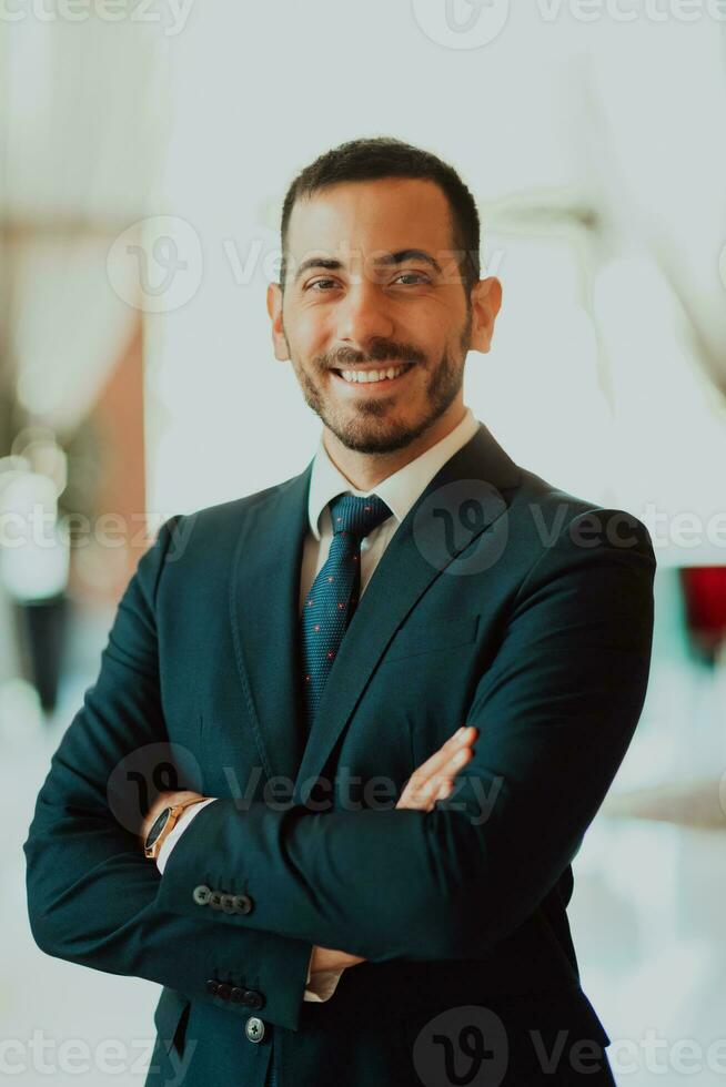 Portrait of a businessman in a suit with his arms crossed in a modern office building photo