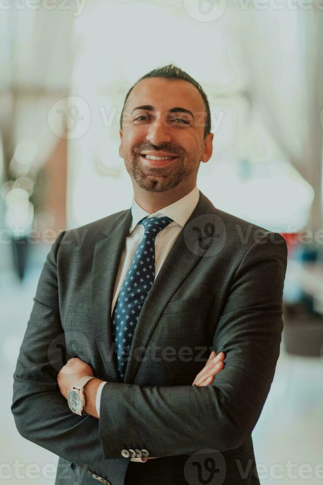 Portrait of a businessman in a suit with his arms crossed in a modern office building photo