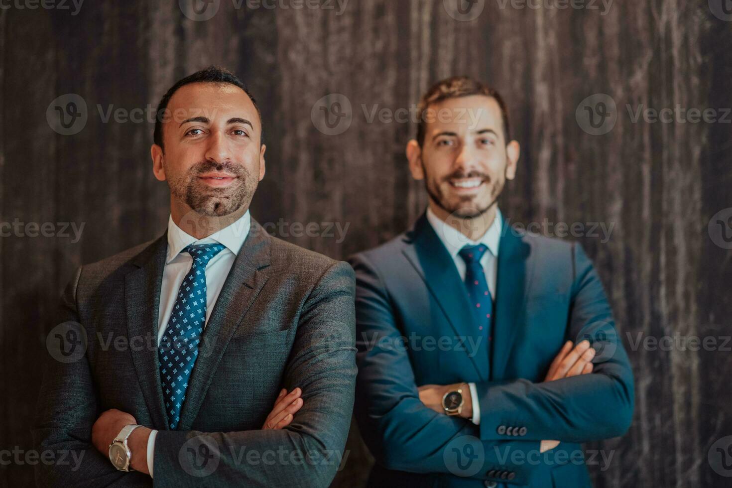 Portrait of two businessman in a suit with his arms crossed in a modern office building. Selective focus photo