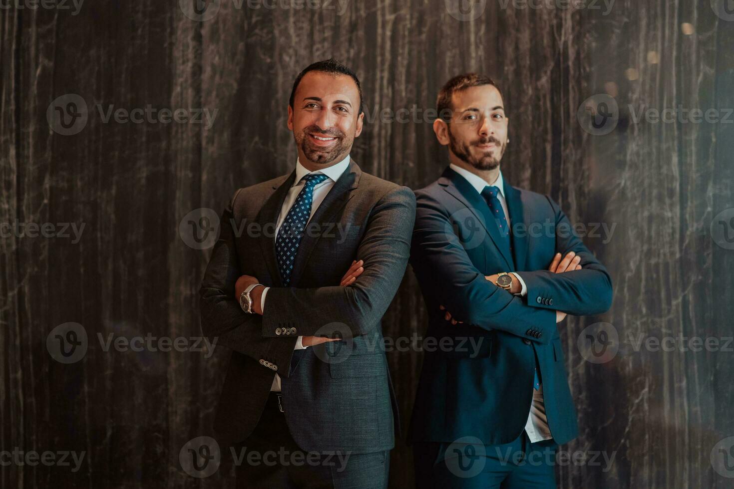 Portrait of two businessman in a suit with his arms crossed in a modern office building. Selective focus photo
