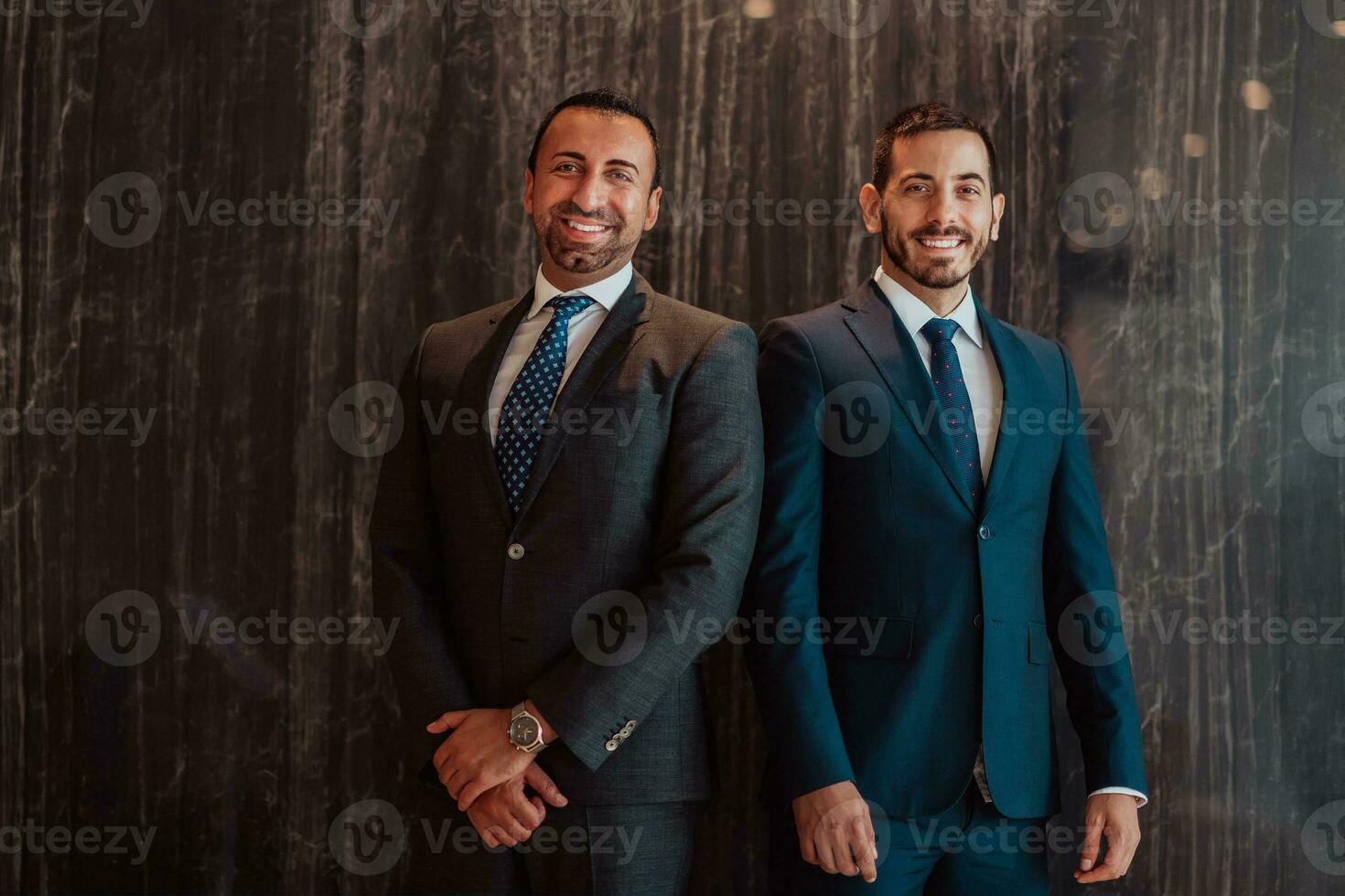 Portrait of two businessmen in a suit with his arms crossed in a modern office building. Selective focus photo