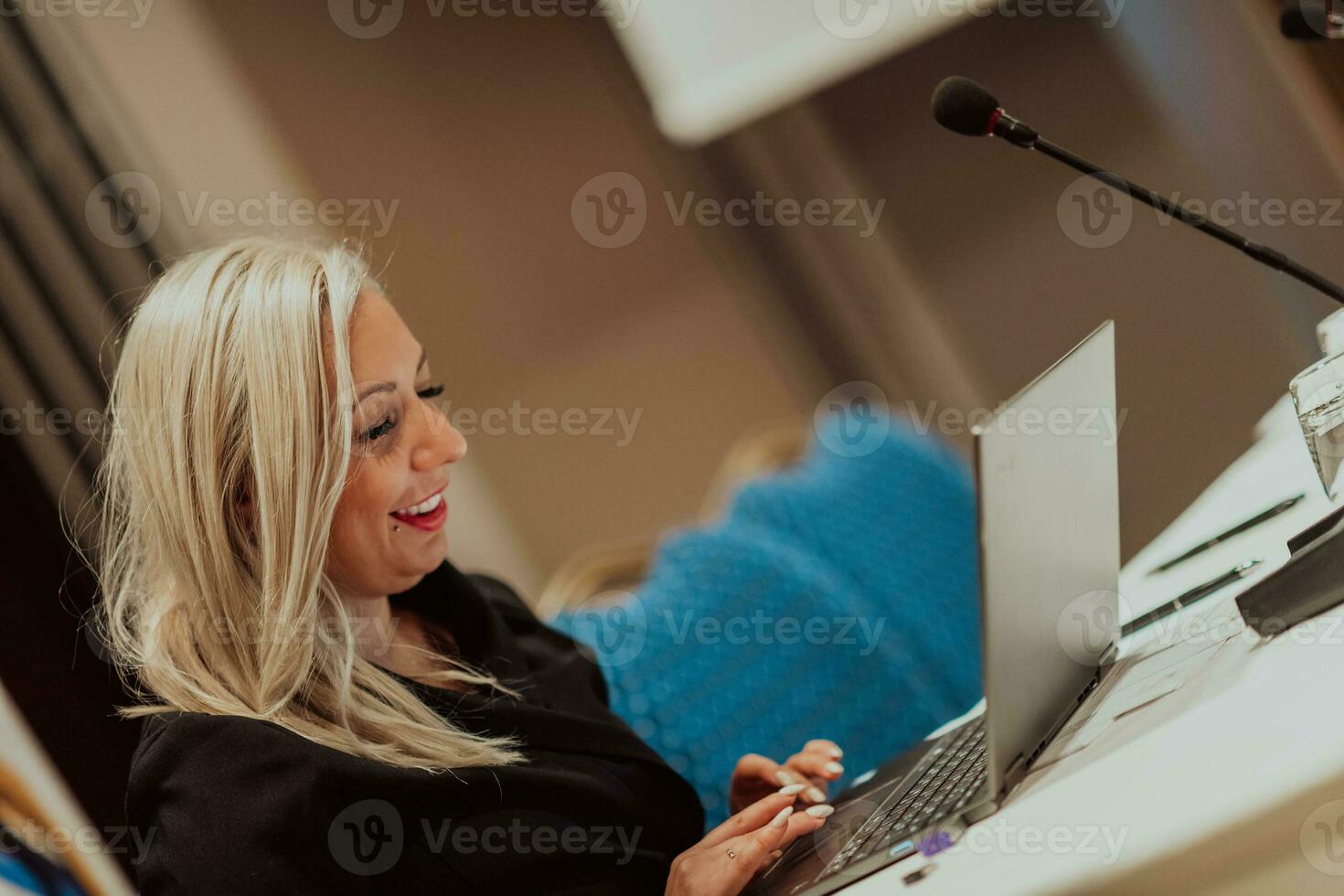 Photo of an elderly woman using a laptop to carry out business projects and tasks while sitting in a modern corporation