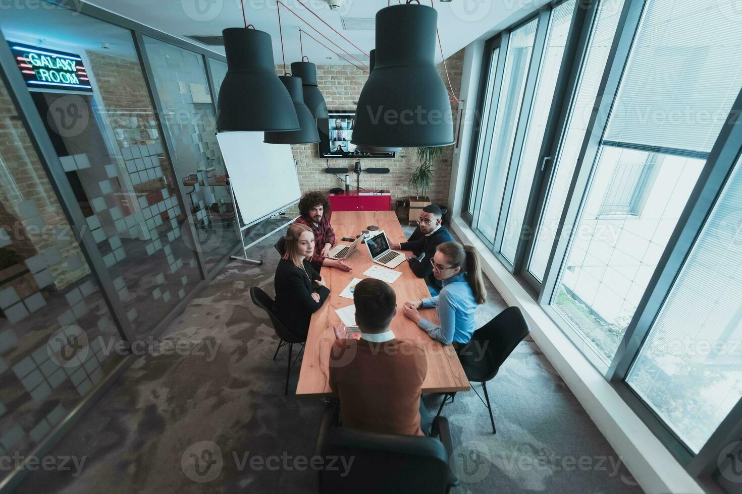 Top view of young multi-ethnic business people working and communicating together in creative office. Selective focus photo