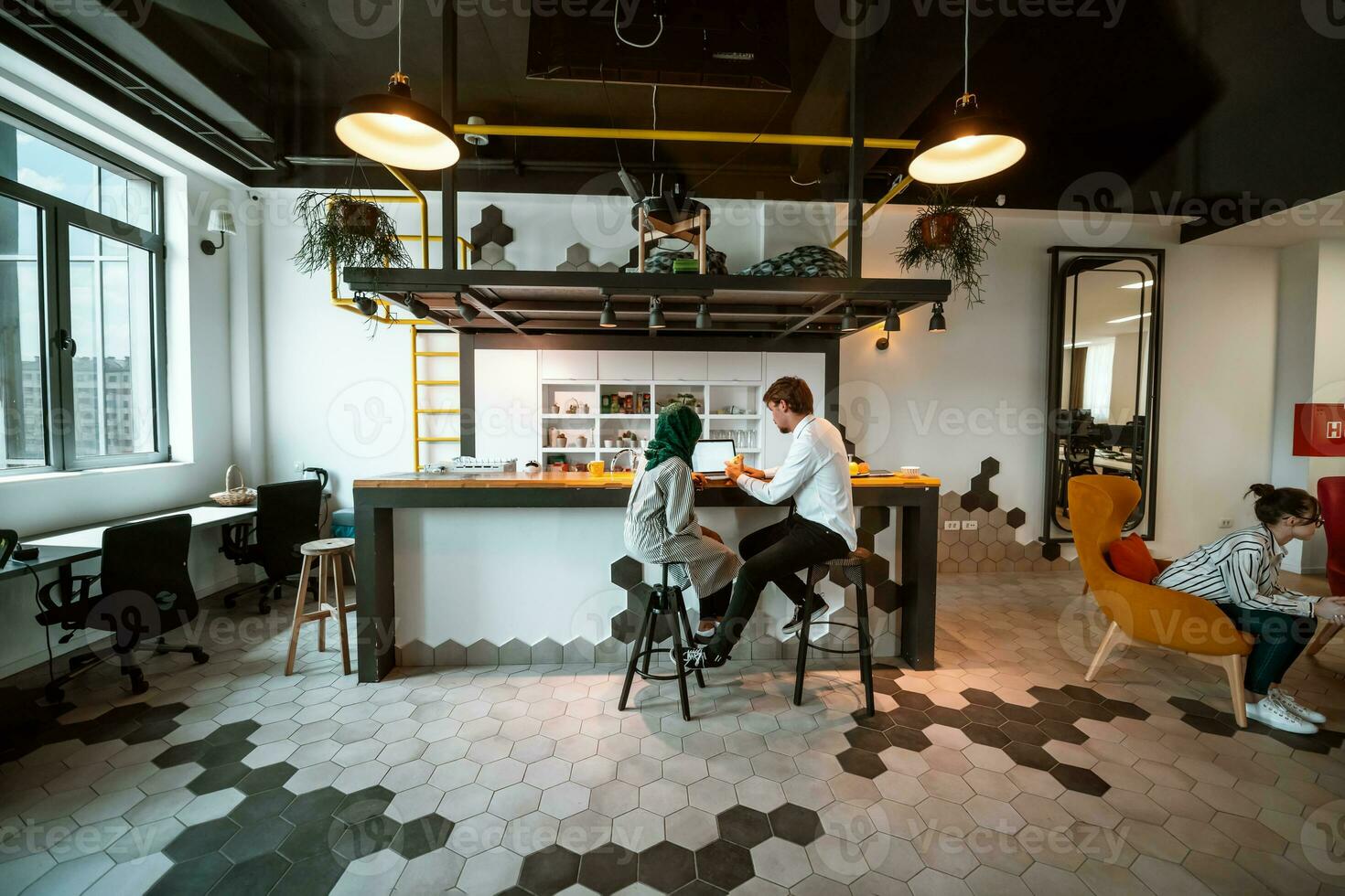 Group of casual multiethnic business people taking break from the work doing different things while enjoying free time in relaxation area at modern open plan startup office photo