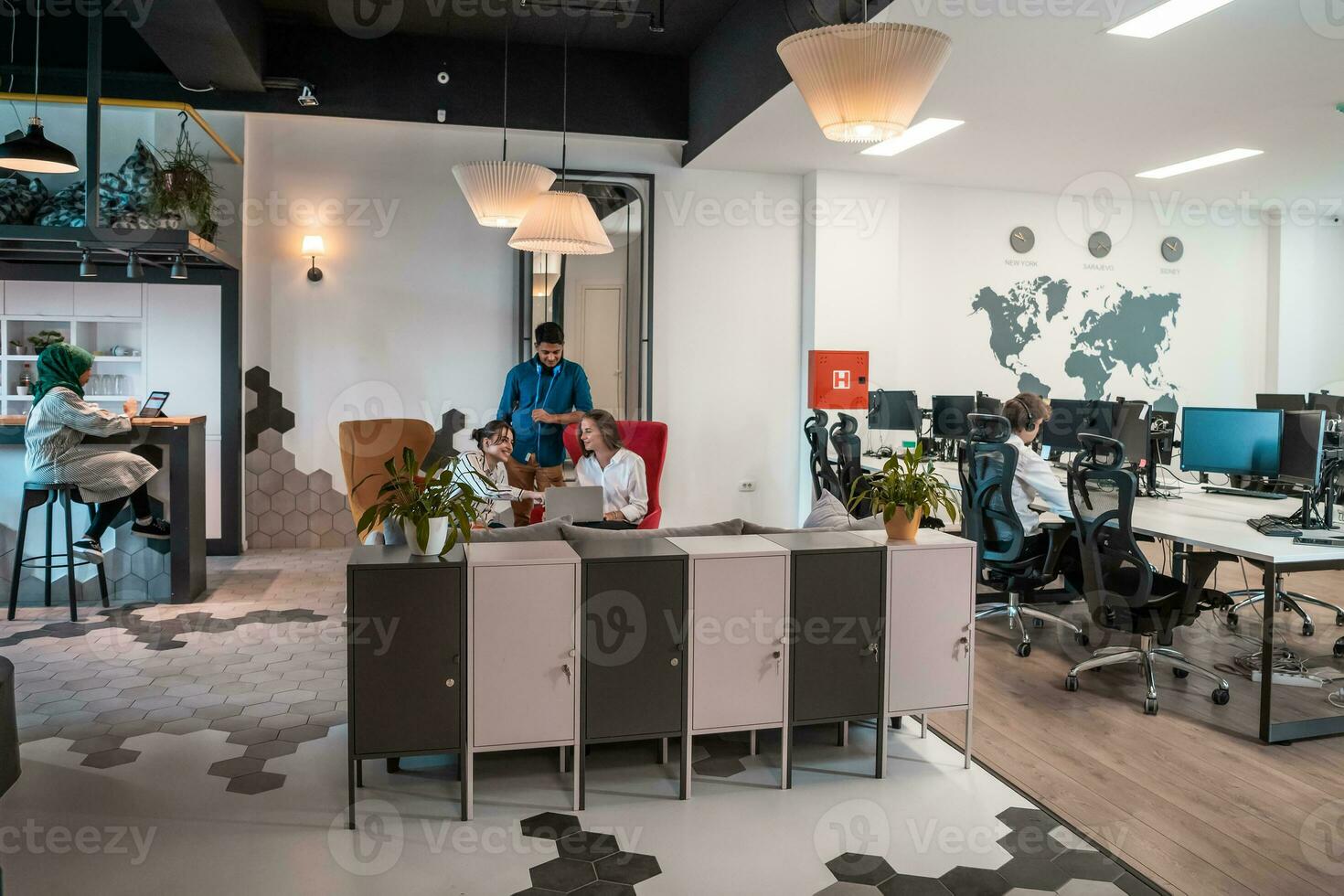 Group of casual multiethnic business people taking break from the work doing different things while enjoying free time in relaxation area at modern open plan startup office photo