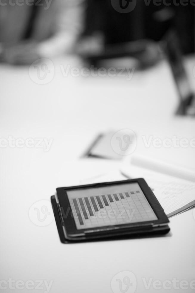 close up of touchpad with analytics documents at business meeting photo