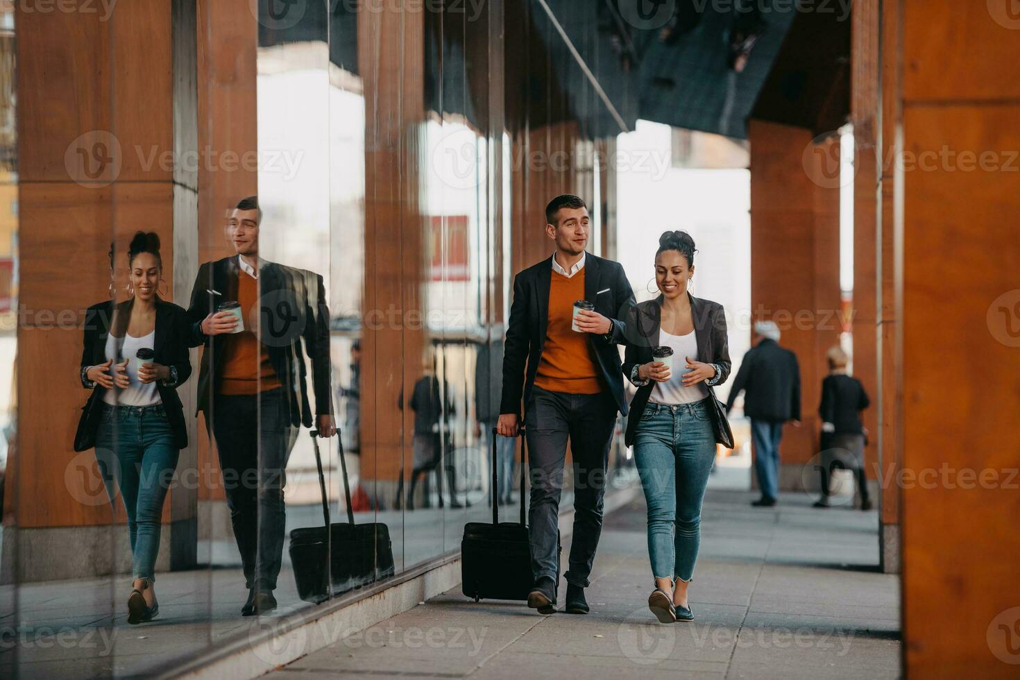 Business man and business woman talking and holding luggage traveling on a business trip, carrying fresh coffee in their hands.Business concept photo