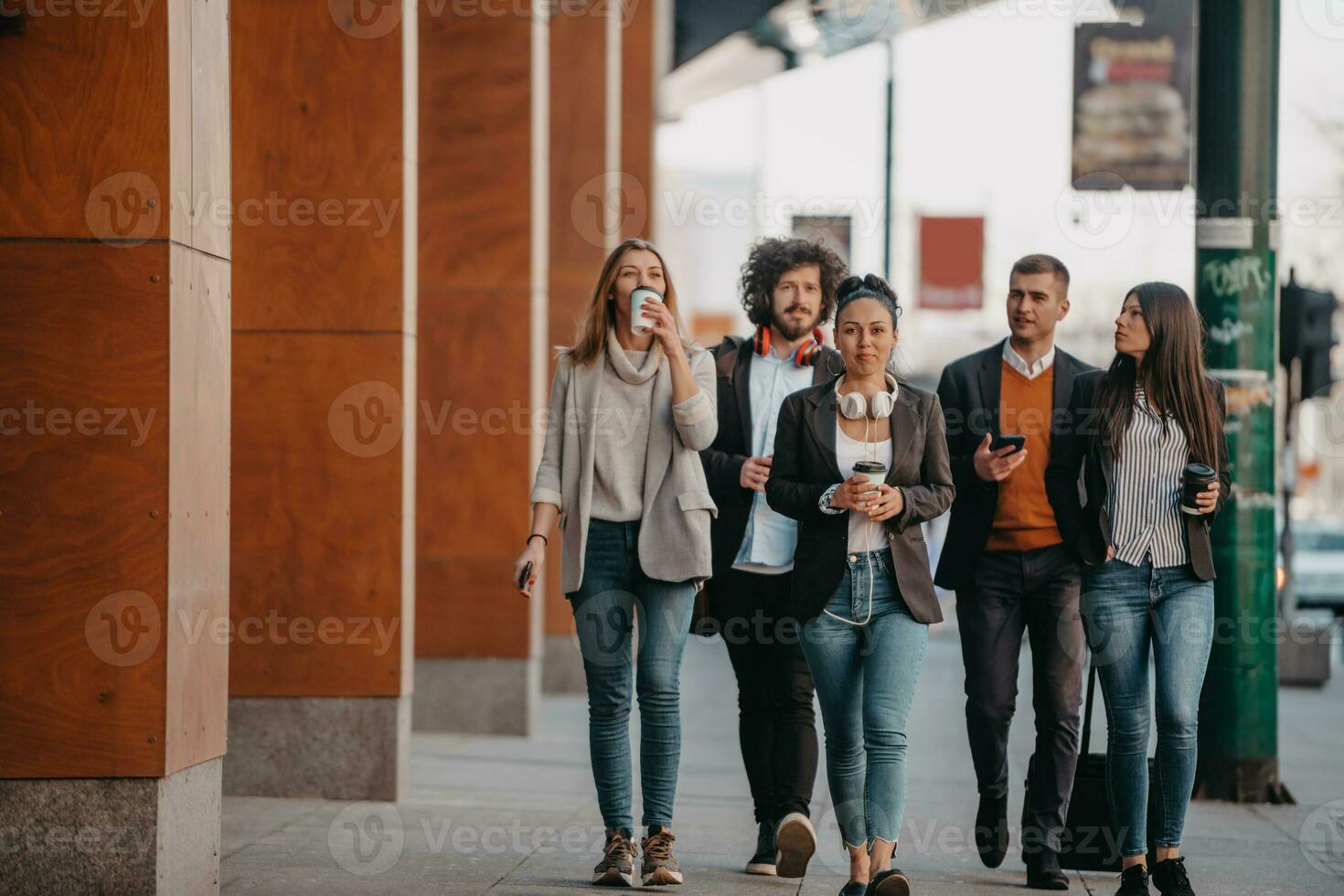 Travelers business team of colleagues walking and talking on modern urban city streets. People on out of the office on break. photo