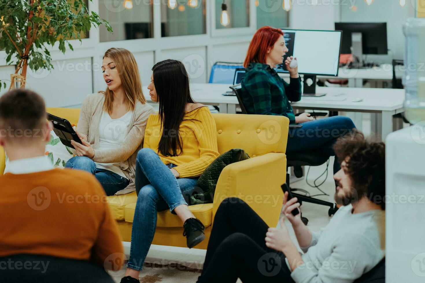 Group of multi-ethnic colleagues working on desktop computers, laptop and sharing their ideas in a modern office space.Young influencers work on online marketing projects. photo