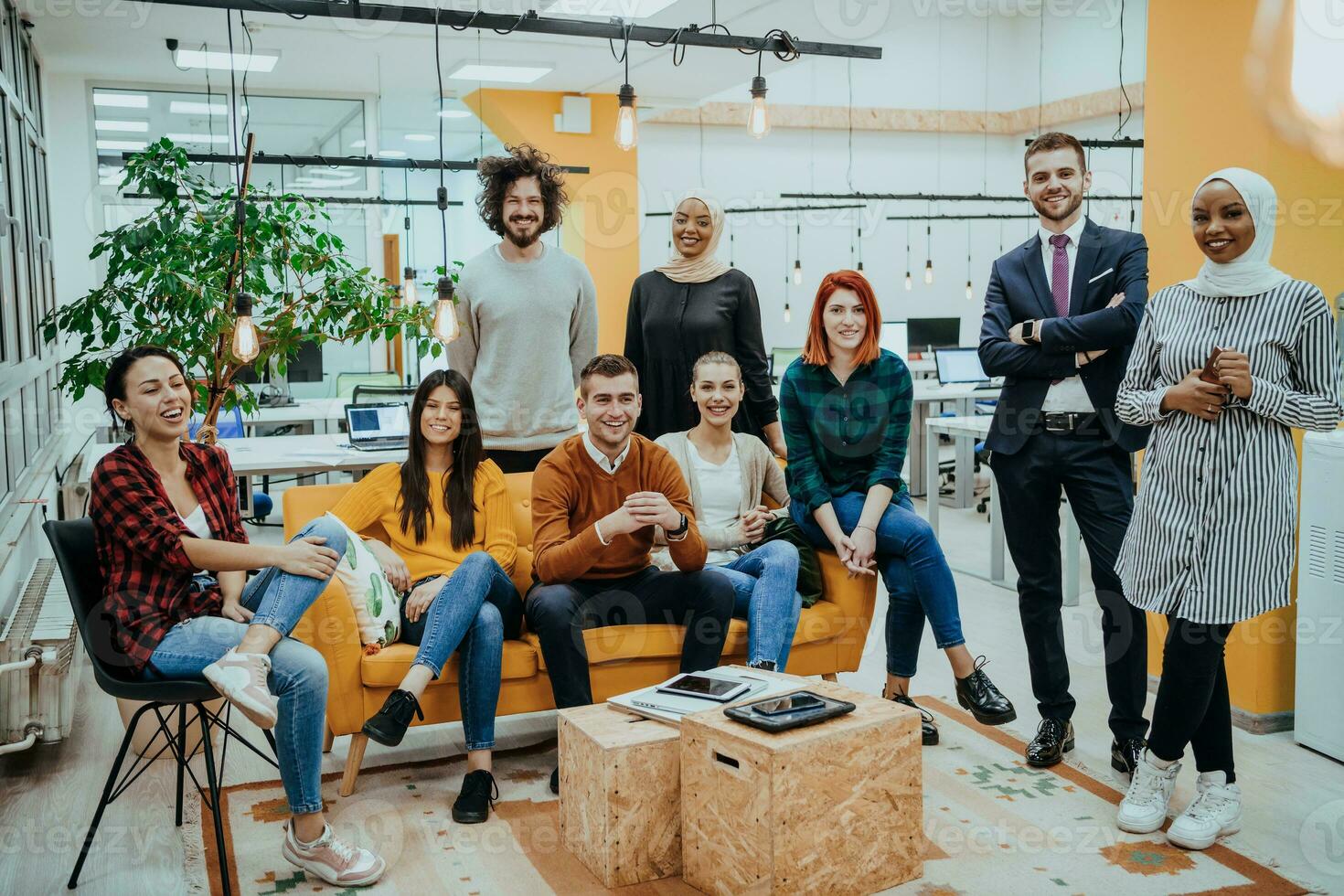 Group of multi-ethnic colleagues working on desktop computers, laptop and sharing their ideas in a modern office space.Young influencers work on online marketing projects. photo