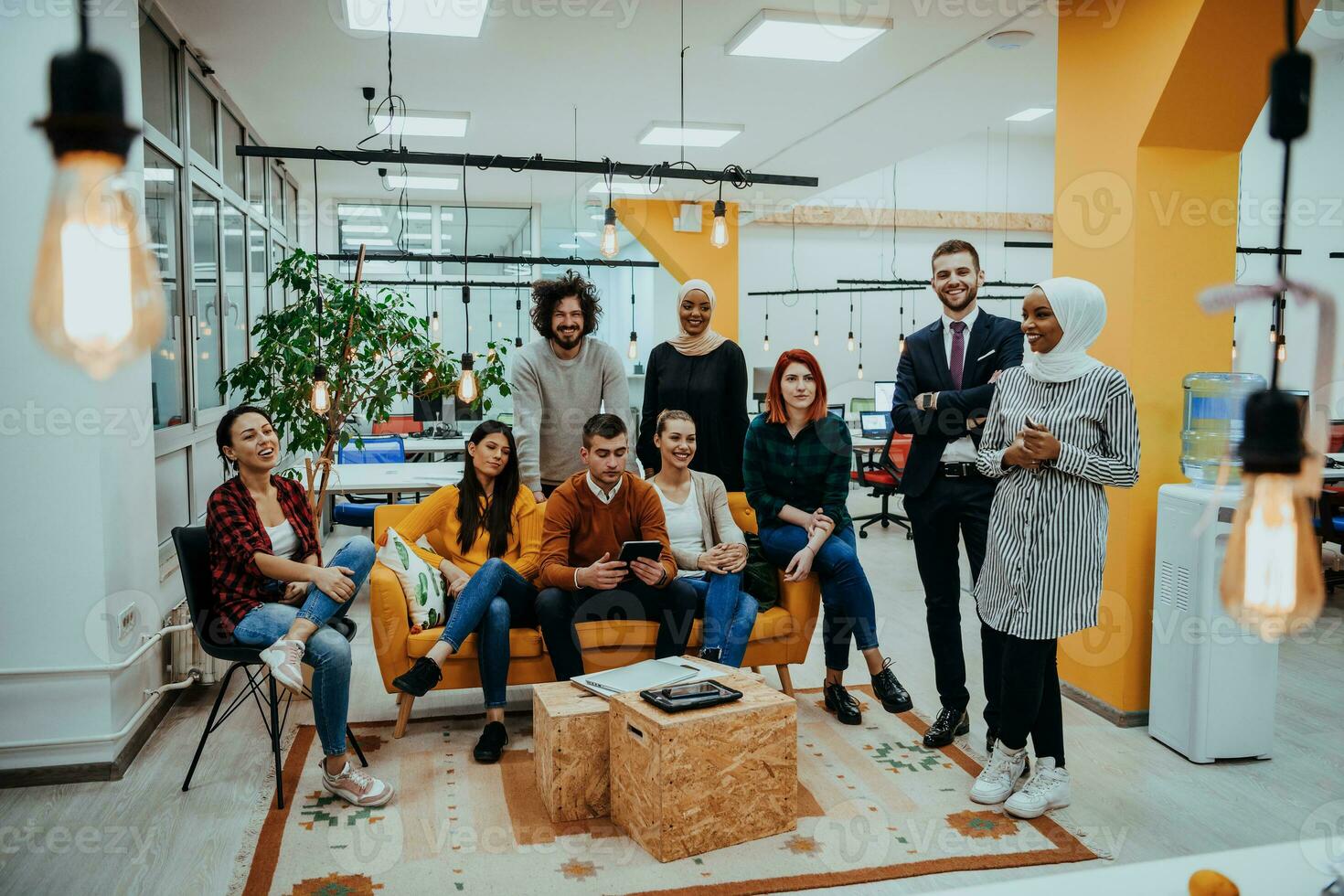 grupo de multiétnico colegas trabajando en escritorio ordenadores, ordenador portátil y compartiendo su ideas en un moderno oficina espacio.joven influencers trabajo en en línea márketing proyectos foto