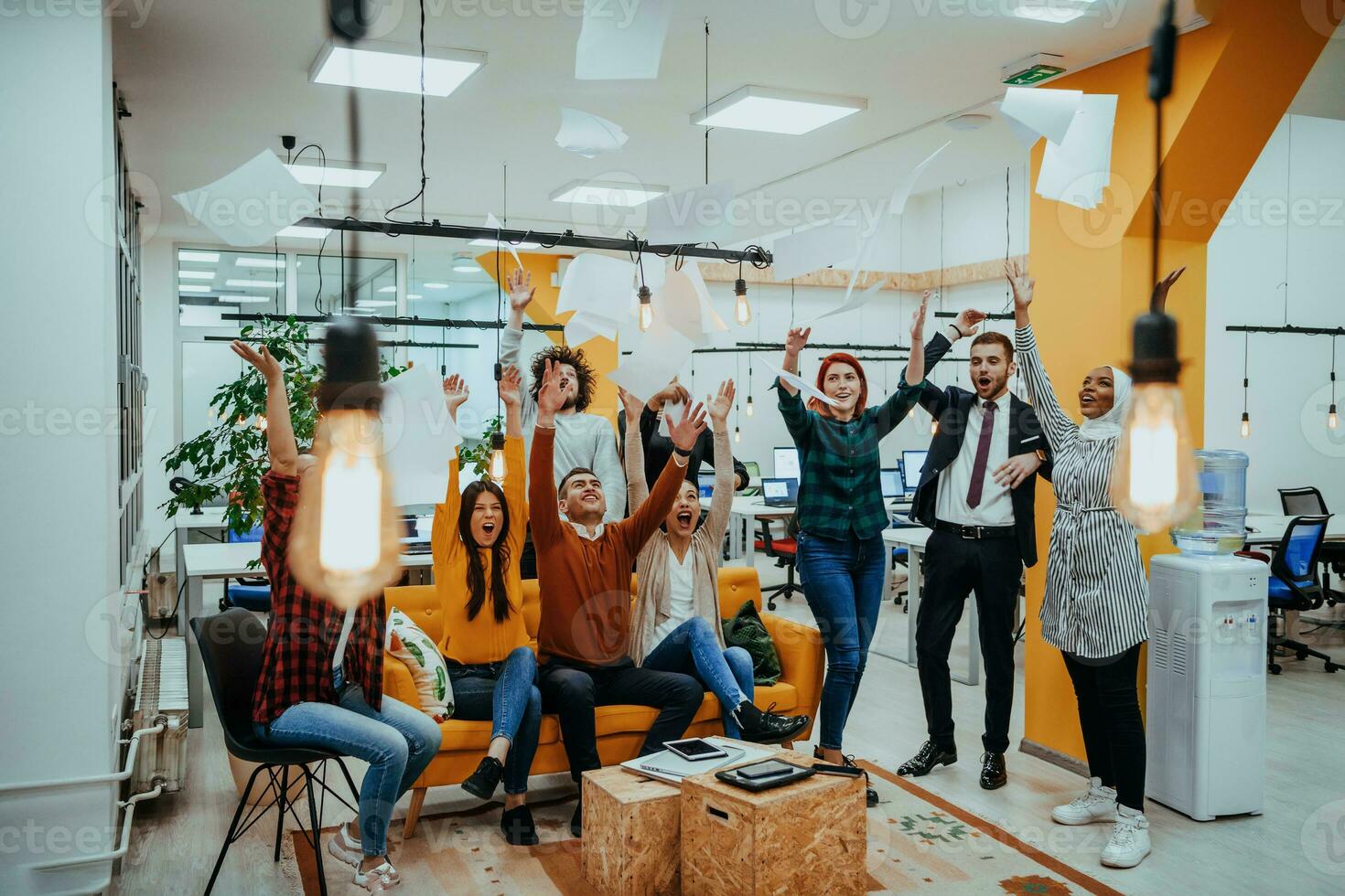 Group of business people throwing paper in air at modern startup office, team success and job done concept photo