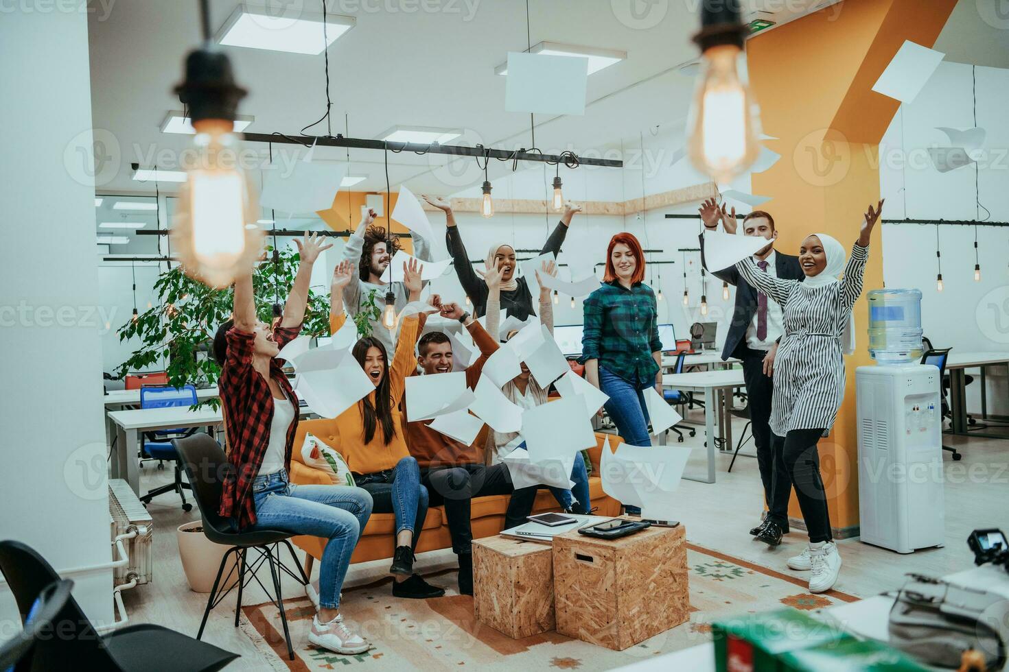 Group of business people throwing paper in air at modern startup office, team success and job done concept photo