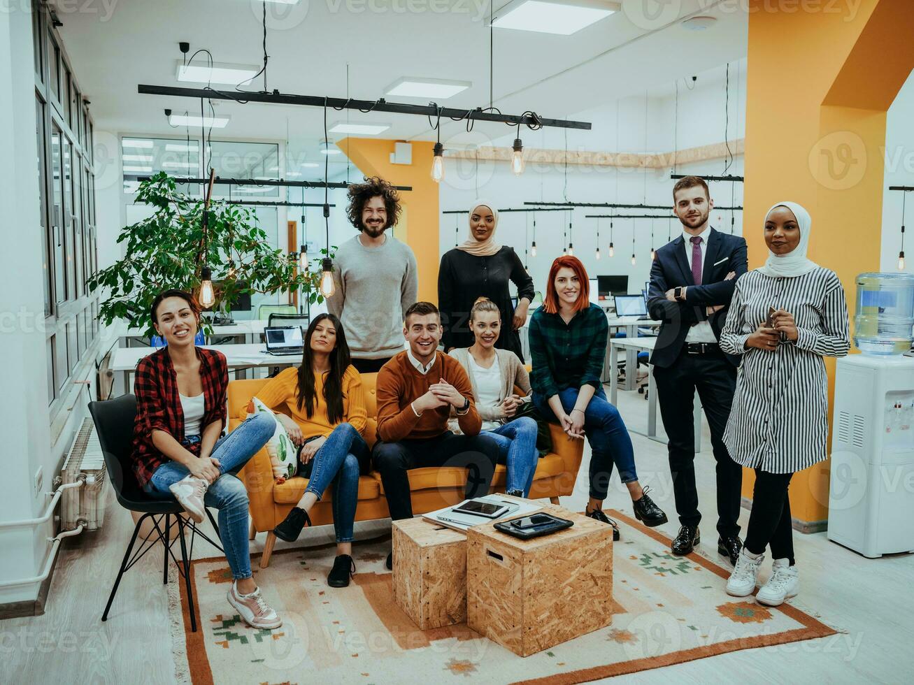 grupo de multiétnico colegas trabajando en escritorio ordenadores, ordenador portátil y compartiendo su ideas en un moderno oficina espacio.joven influencers trabajo en en línea márketing proyectos foto