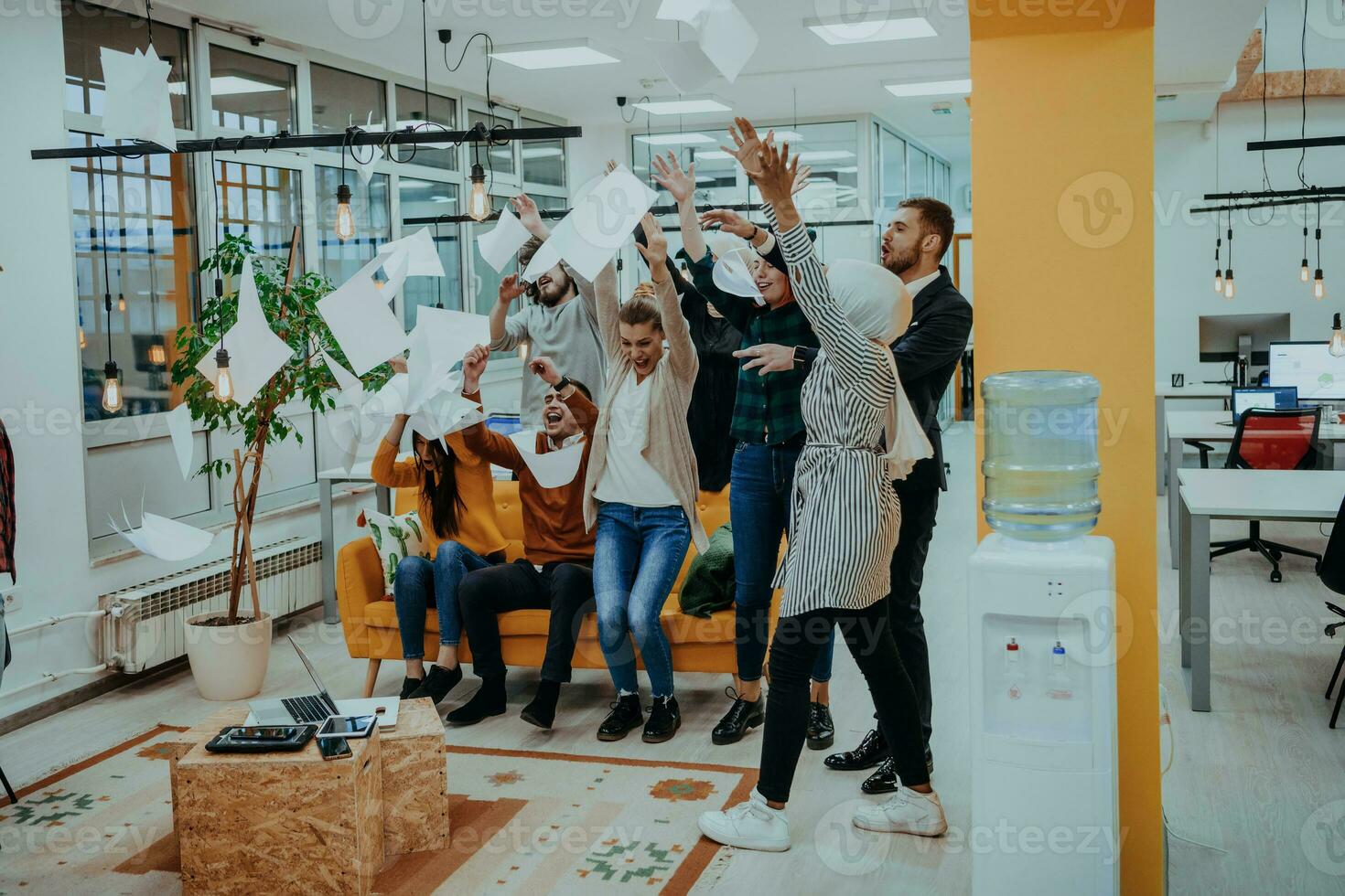 Group of business people throwing paper in air at modern startup office, team success and job done concept photo