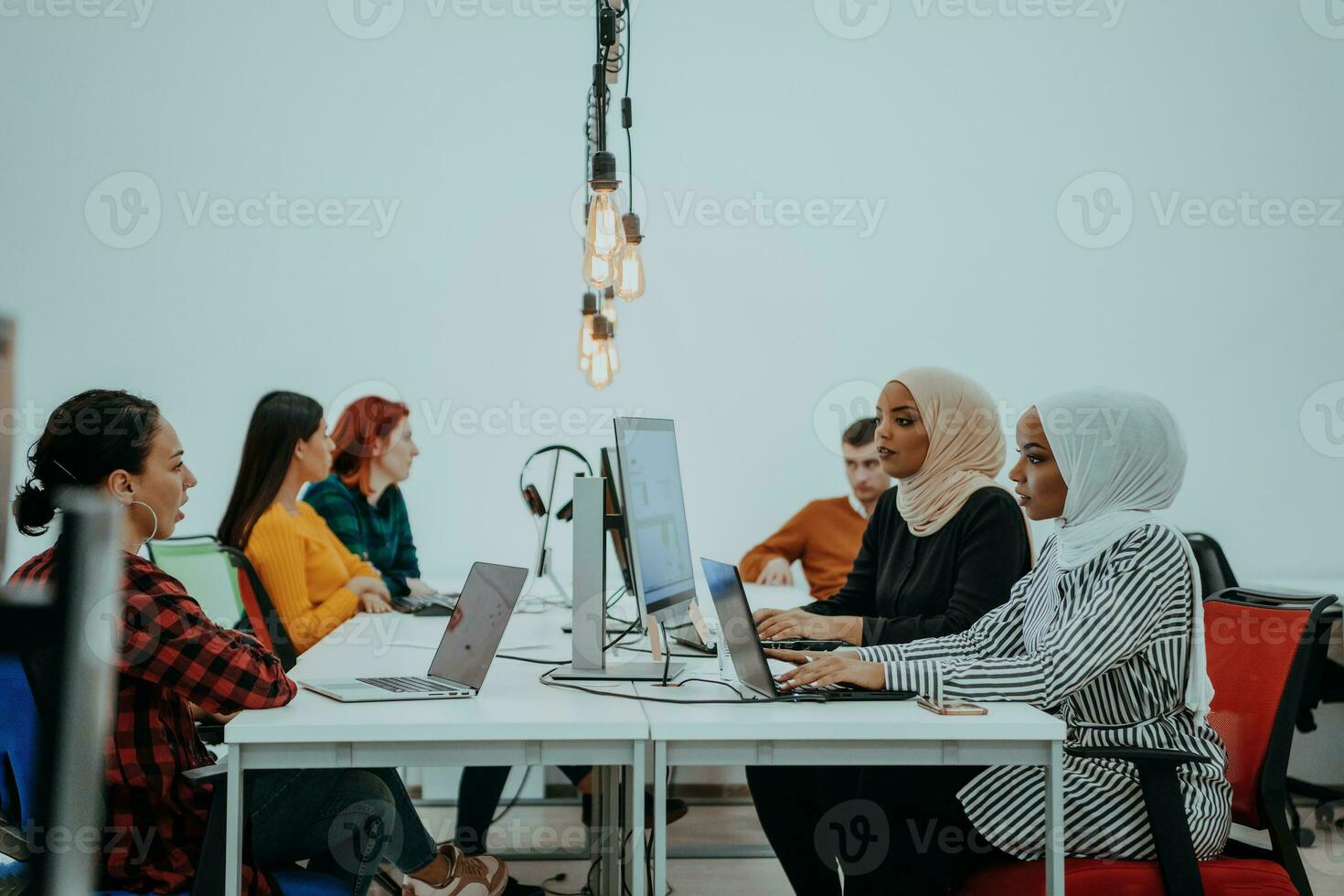 Multiethnic group of employees working in a marketing company. A group of colleagues is working on a project in modern offices photo