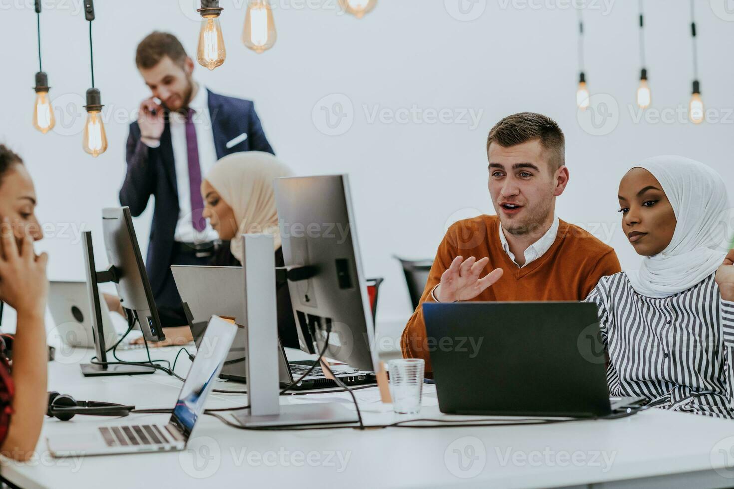Multiethnic group of employees working in a marketing company. A group of colleagues is working on a project in modern offices photo